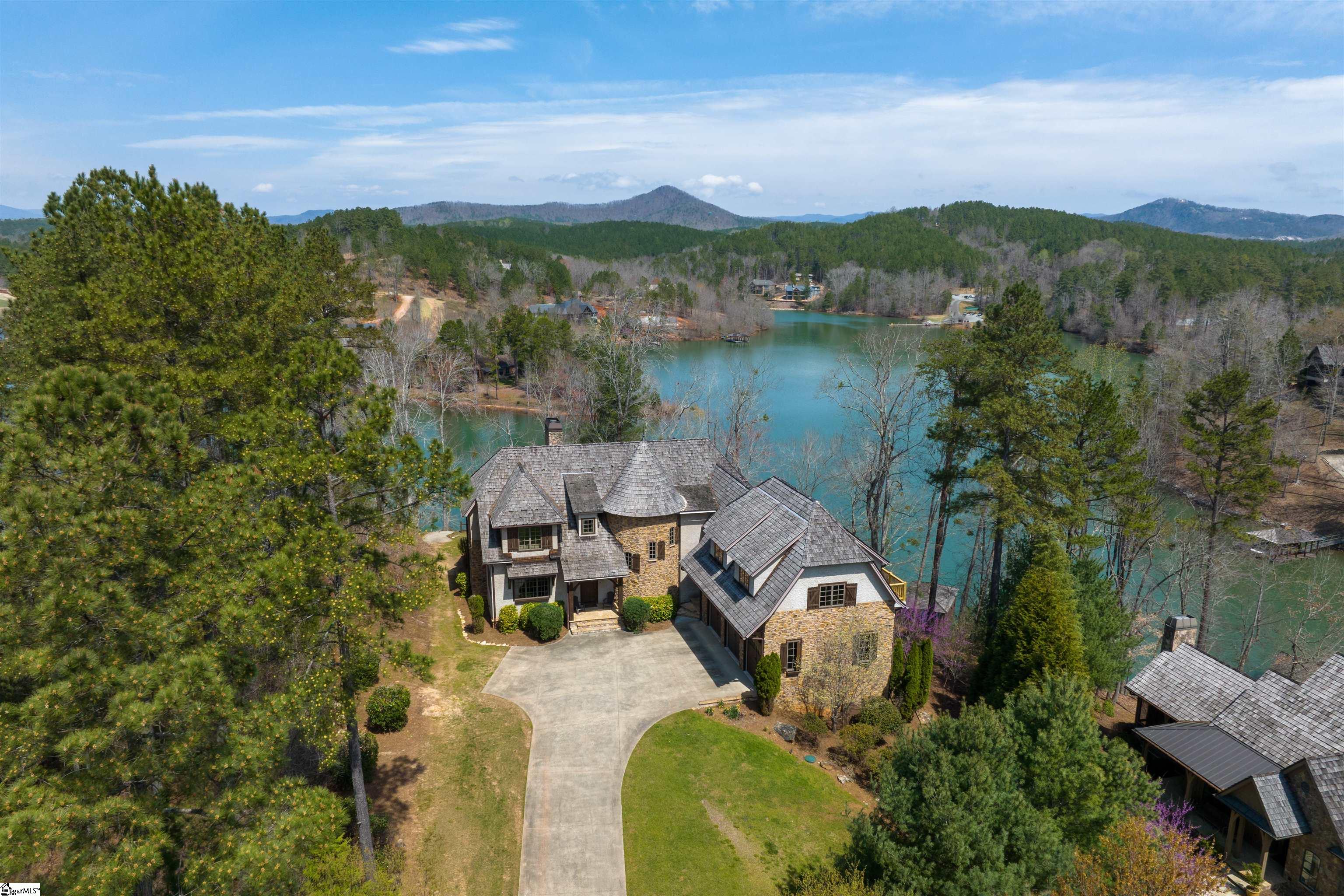 WATERFRONT! Custom waterfront home in Settlement section of the Reserve at Lake Keowee. Covered dock, deep water! LAKE VIEWS from almost every room! Your castle awaits, featuring a stunning winding staircase with domed ceiling inside stone turret which provides access to the upper level. Move in ready, rich wood finishes, high ceilings, half-circle archways, gorgeous floors. Great Room with soaring ceiling and limestone fireplace, the central gathering/entertaining space. Spacious Chef's kitchen with high end appliances and ample prep space with its very own gas log fireplace. Directly off the kitchen, there is access to the covered porch for entertaining overflow. First Floor Master enjoys LAKE VIEWS and access to covered porch. EVERY bedroom has LAKE VIEWS! Bonus: 2-Room Guest Suite above 3 car garage with W/D, beverage fridge and snack bar with private balcony. Office/library with double glass doors. The upper level consists of three bedrooms and two full baths. One of the bedrooms has private access to an open-air flagstone patio that was recently restored; two   bedrooms share access to the adorable Jack-N-Jill bath. There is an interior room with no windows that would be ideal to set up as a media room. Unlimited storage throughout this beautiful home. The Reserve at Lake Keowee is a gated lakefront golf community offering over $100 million in world-class amenities including recently renovated Jack Nicklaus Signature Golf Course, par 3 practice facility with driving range and bar, Clubhouse with fine dining, pub, wine bar, Fitness Center, hiking trails, Tennis & Pickle Ball Courts, Pool and Cabana, Marina and Village Market. The Settlement section has its very own Pool Pavilion/fitness. Premier membership initiation deposit: $60,000 required at closing.
