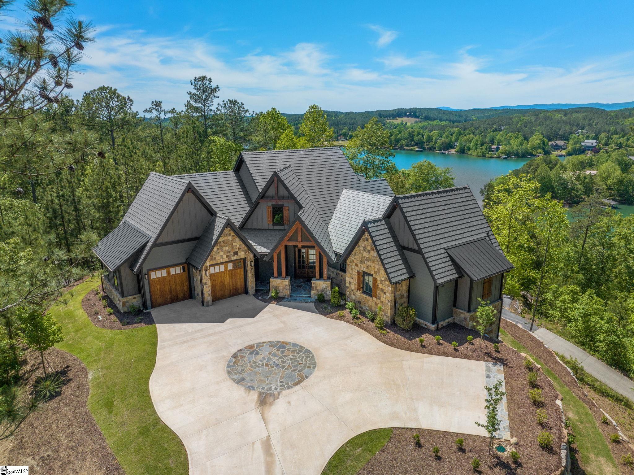 BRAND NEW home with plunge pool and lake/mountain views!! If you have been searching for that elusive Lake Keowee home with A VIEW, this is it! Views! Views! Views! This brand new, custom 4600 sf home in The Reserve, crafted by Arcon Architects & Builders, sits high up on very private acre lot overlooking crystal clear Lake Keowee and the great Smokey Mountains. Attention to detail is everywhere! Custom stonework, conditioned heated plunge pool with retractable cover, expansive decks with gas fireplaces, and so much more! MAIN LEVEL master suite, with his and hers separate bathrooms and walk-in closets designed with direct access to the main level deck. The easy open-flow living/dining combination includes gourmet kitchen, ideal for entertaining, with a stunning granite island, Thermador appliances, and a unique scullery with its own prep area and sink, double ovens, and abundant custom cabinetry. A step away is the Great Room with its stone-encased electric fireplace, built-in display shelving, unique ceiling design with wood inlays, and floor-to-ceiling sliding glass doors with transom windows. The TERRACE LEVEL begins at its center with a spacious rec/sitting room opening directly to the covered patio, outdoor fireplace, and plunge pool. On one side, there is a full guest suite with private bath and patio access, with an additional guest suite with breakfast bar, bonus room and full bath at the other end. Exiting off the pool deck is a terrace level mudroom with a half bath and is plumbed for an additional washer/dryer. There is also existing plumbing and drain for an outdoor shower if desired. Loads of custom storage space, an unfinished safe room, and built-in shaft for a future elevator completes this level. There are thoughtful design features throughout: A two-car garage with ample space for work benches and storage including an elevated roof on one side designed for the installation of a car lift. Entering from the garage, there is a mudroom, walk-in coat room, and a large laundry. The lower-level mechanical room even has its own entrance. Private, gated Reserve at Lake Keowee offers a Jack Nicklaus Signature Golf Course, a par 3 practice facility with driving range, Clubhouse with fine dining, pub area & wine bar, Fitness Center, Hiking Trails, Har-Tru Clay Tennis Courts, Lakeside Resort-Style Pool and Cabana, Settlement Pool, new Pickleball Courts, Marina offering both slips and boat rentals, and Market great for lunch and select provisions. This community offers many activities including fitness classes, various social clubs, and a high-speed fiber-optic internet system in place. The Reserve at Lake Keowee is a full amenity lakefront golf community. Must see! Start making your memories today! Sports Membership deposit is required at closing. An upgrade to RLK Club premier membership (for golf, fitness, tennis, pickleball) is possible for an additional fee; contact listing agent for details.