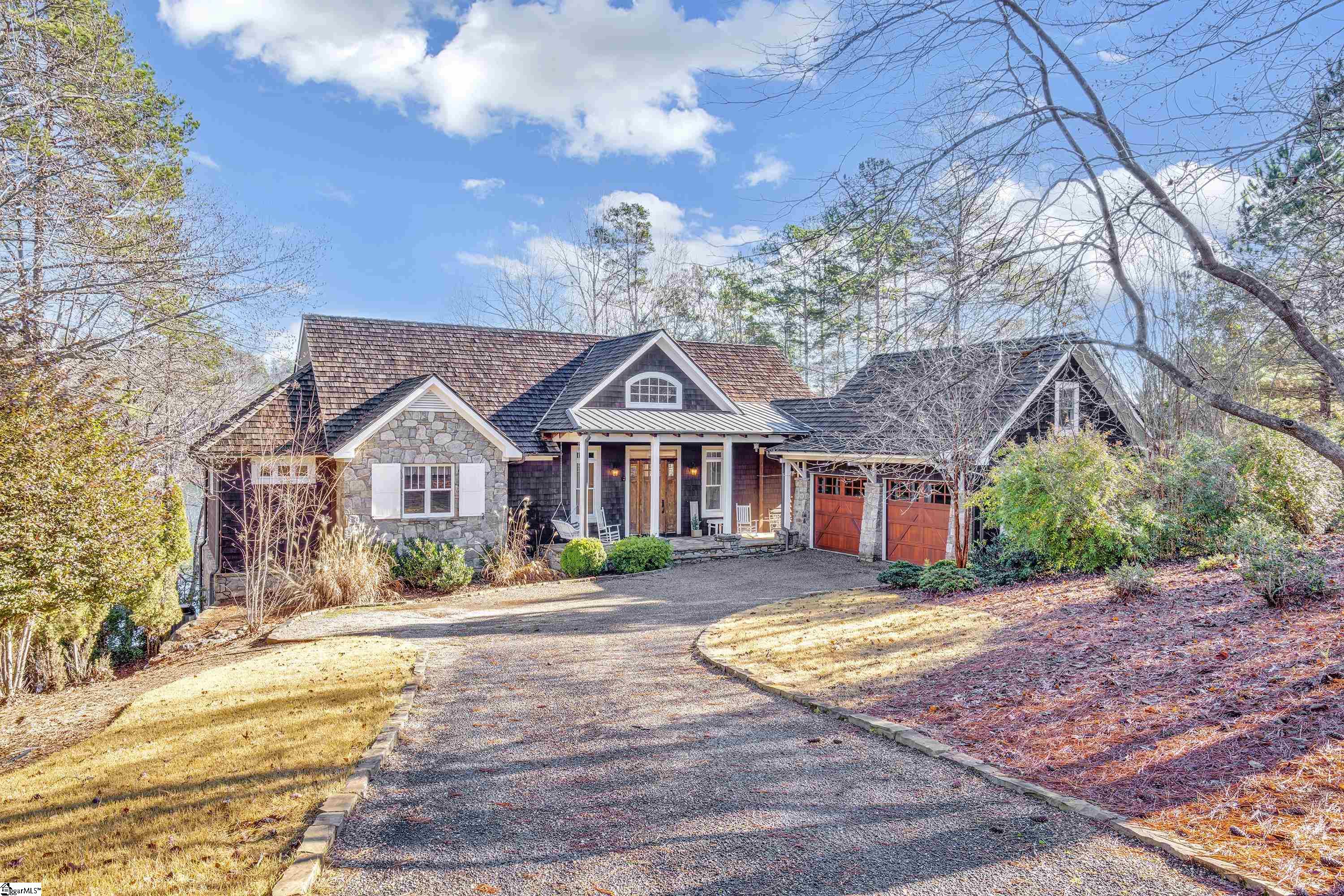 This perfect Lake Keowee waterfront home is situated on an easily maintained, VERY gently sloped homesite in one of the best areas of The Reserve! A pretty front porch wraps into a side grilling porch under breezeway. The main level open living space has heartpine floors, majestic floor to ceiling stone fireplace, lots of natural light from windows, a wood-paneled, vaulted ceiling. The lakeside rear of home faces east, with incredible views overlooking a large, deep-water cove. The spacious main level outdoor deck is about 800 sf; almost half is under roof. Custom cabinetry & built-ins are throughout. The kitchen features 2 dishwashers & Dacor gas cooktop. Master suite on main level, as well as one guest.All 4 bedrooms have adjoining baths; in addition, a guest suite is in bonus over garage. Terrace living area has slate floors, stone fireplace. Easy access to lakeside terrace and covered dock (with lift) via stone steps with handrails. The level side yard is a great play area.Laundry is situated on the main level. Gentle drive leads to double garage. RLK club premier membership fee of $72,000 is not included in sales price; fee is required & due at closing.