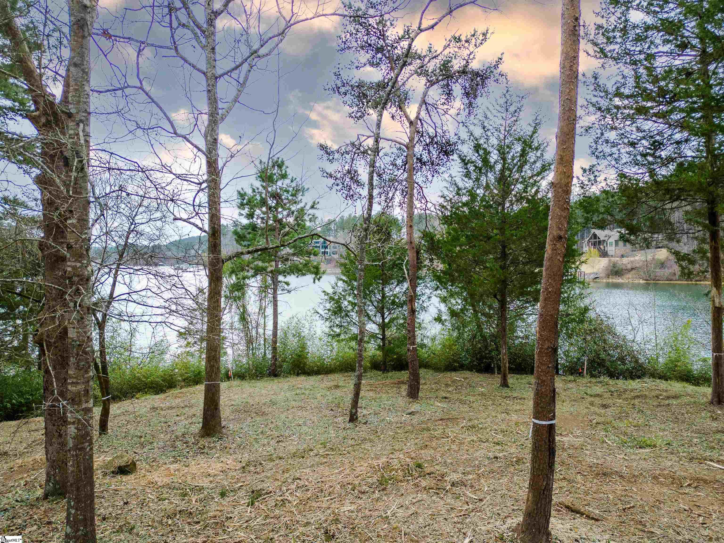 A rare opportunity to own an island retreat in one of the premier community enclaves on spectacular Lake Keowee. This waterfront 1.67-acre beauty features loads of glorious shoreline and lies within The Cliffs at Keowee Springs, where an amenity-rich environment surrounds your future dream home’s panoramic lake views. The unique peninsula homesite is made even more desirable by its topography, allowing an easy stroll on a gently sloping grade to the shimmering shoreline, where a newly installed dock will launch your family’s sunset cruise and fun adventures on the lake. Tucked away in a quiet cove, the lot is fully encircled by a waterfront expanse with multiple beach areas. Quick access to open water and golf excursions by boat to nearby Cliffs’ Falls and Vineyards communities. The new Keowee Springs Clubhouse is under way and will open at the Tom Fazio-designed golf course in 2024, joining the Beach Club and The Landing Lake Club as neighborhood sporting, wellness and social amenities unrivaled anywhere on the lake. Situated 20 minutes from downtown Clemson. The nationally renowned shopping / restaurant and arts district in Greenville is only 45 minutes away. Capture your legacy coming to life on one of the last remaining premier lots on Lake Keowee. Building envelope easily accommodates various custom home designs. To help expedite the building process a copy of completed tree and topographic survey, custom home and site plans are available. A Cliffs membership is available for purchase.