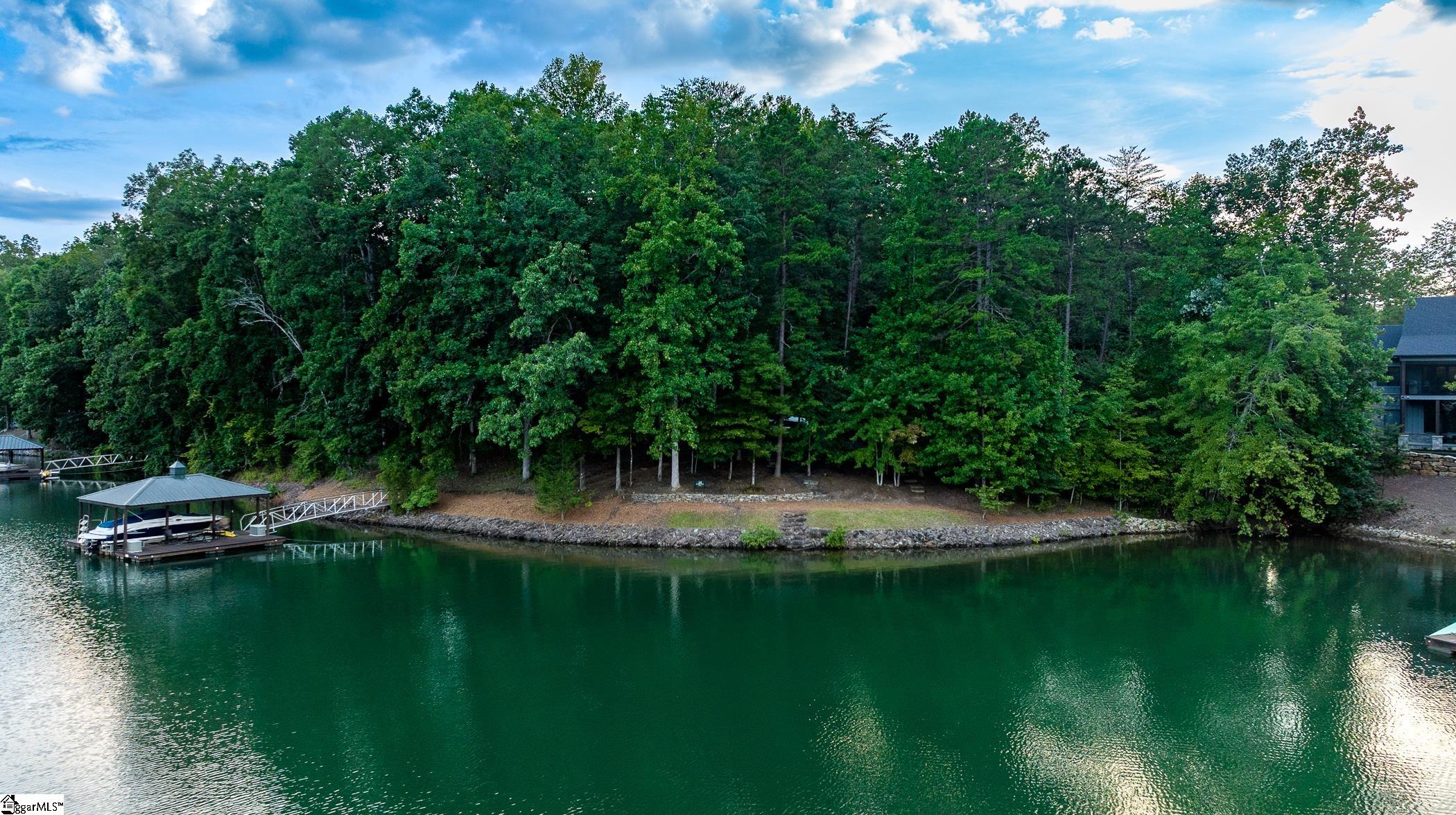 126 Bright Water Trail is situated on one of the more secluded coves in the Cliffs at Keowee Springs, and this 1.69-acre property is a build-ready spot for the home of your dreams. Located in one of the most desirable areas in the Springs, it combines a tranquil setting typically less traveled by boat traffic with a long channel view, culminating with the sight of “the farm” off channel’s end, a local boating landmark. A wonderful place for your family to float off the dock, swim, paddle board, kayak or fish.   The site is gently sloped to the water, and much of the hard work and expense is already done. This includes approx 271' of lake frontage, stone shoreline reinforcement, a temporary gravel drive for access, a dock with a boat lift approved by Duke Energy, as well as water and electric utilities installed. Its location offers excellent options for your home site that will take full advantage of this pristine location. It also enjoys deep water, with the stern of your boat typically sitting over roughly 15 feet of water when docked.  With the recent amenities and expansion of facilities (new clubhouse opening soon) at the Springs, and the outstanding qualities and pre-work completed on this site, this property makes a strong case for anyone who wants to experience quality living in a great community.  With multiple homes, the current owners have enjoyed this location for years of lakefront memories but are ready to relinquish it to the next owner. For the golfer, the boater, the extended family or as a future retirement haven, 126 Bright Water Trail has all the ingredients that the Cliffs at Keowee Springs has to offer. A right to purchase a Cliffs Club membership is available.  **Boat is not included with the property.**