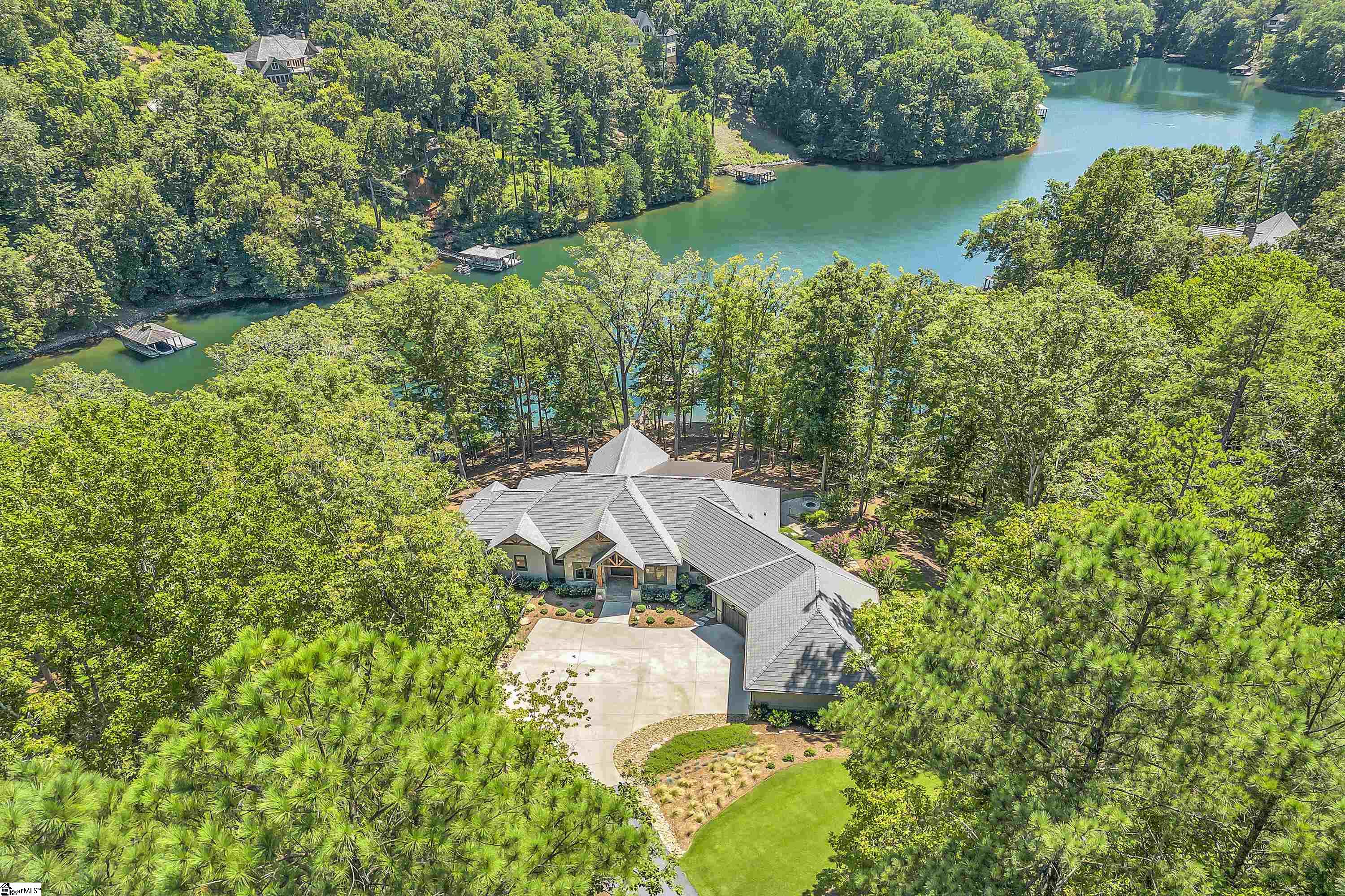 Located on one of the most sought-after sections in The Reserve, this meticulous custom home truly captures the essence of Lake Keowee living. Nestled in a cove off the main channel, this stunning home provides unparalleled water views with nearly 270 feet of shoreline. Inside, you'll find an expansive living room, dining area, and kitchen, along with a fabulous keeping room boasting exquisite water views from every room. The main floor also features a serene primary bedroom with a luxurious bath, perfect for your own private getaway even when hosting large groups. Outside, the sprawling deck with phantom screens provides plenty of space for entertaining or simply pure relaxation. You’ll also enjoy the grill masters dream station with easy access into the main kitchen. The home also offers four additional bedrooms, one that can serve as a second primary suite with heated bathroom floors, a bunk room, a bar, wine closet, and a spacious bonus area for games with family and friends. Don't miss the oversized 3 car garage, additional entertaining space with walk out patio and fire pit area, and tons of storage. Just a short walk to your private dock which provides easy getting to and from the home after a perfect day on the lake. The spirit of Lake Keowee is truly captured in this beautiful home, while some of the best private club amenities in the southeast are a stone's throw away. RLK Social Membership of $13,000 is required at closing.
