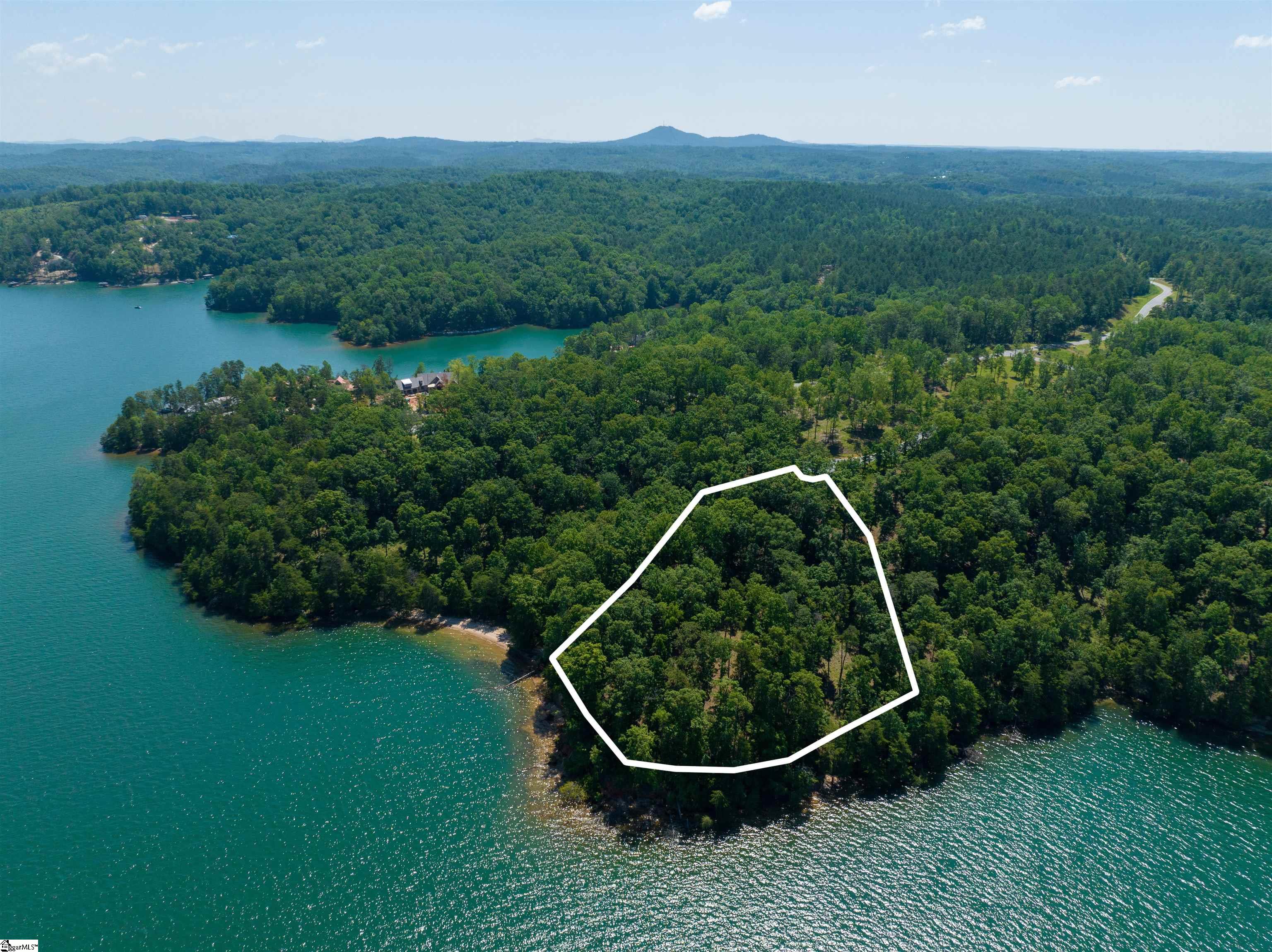 ONCE IN A LIFETIME OPPORTUNITY to secure a slice of paradise on LAKE KEOWEE, one of the most sought-after locations in the Southeast! Whether you are ready to build now or in the future, 233 Sandy Hollow Ct is the ultimate canvas for your lakefront masterpiece. If you are familiar with our Lake Keowee region, you know home sites of this excellence are the most difficult to find! Experience the ultimate luxury lifestyle in the highly sought-after Cliffs at Keowee Springs / The Landing. This spectacular waterfront lot offers stunning long water, mountain, and sunset views. With over 425 feet of pristine shoreline and 2.3 acres, this point lot situated on a private cul-de-sac is a rare find and provides the perfect backdrop for your private custom dream home. An 8,000 square foot estate home plan, specifically designed for this lot by Gabriel Builders, to be included with property. Gabriel Builders is a premier builder of estate homes in Lake Keowee’s most exclusive communities. Alternately, bring your vision to life on this private, stunning lot with your own architect and builder. The Cliffs at Keowee Springs offers unparalleled amenities including golf, tennis, pickleball, pool, the Beach Club, the Sportsman Trail, and the soon-to-be completed new Lakeclub. This multi-purpose complex on the lake will include two swimming pools, a restaurant, and a wellness center. Located on the east side of Lake Keowee, this property provides easy access to Clemson and Greenville for dining, shopping, theater, sporting events, and the GSP International airport. As a member of a Cliffs community, you will enjoy access to all the extraordinary and unique amenities in each of the seven regional Cliffs communities, allowing you to indulge in all the best that The Cliffs and Lake Keowee has to offer. An amazing home site offering for the most discerning buyer. Permitted for Dock. Custom dock design by Kroeger Marine to be made available. Complete home plans available to view for serious inquires only.