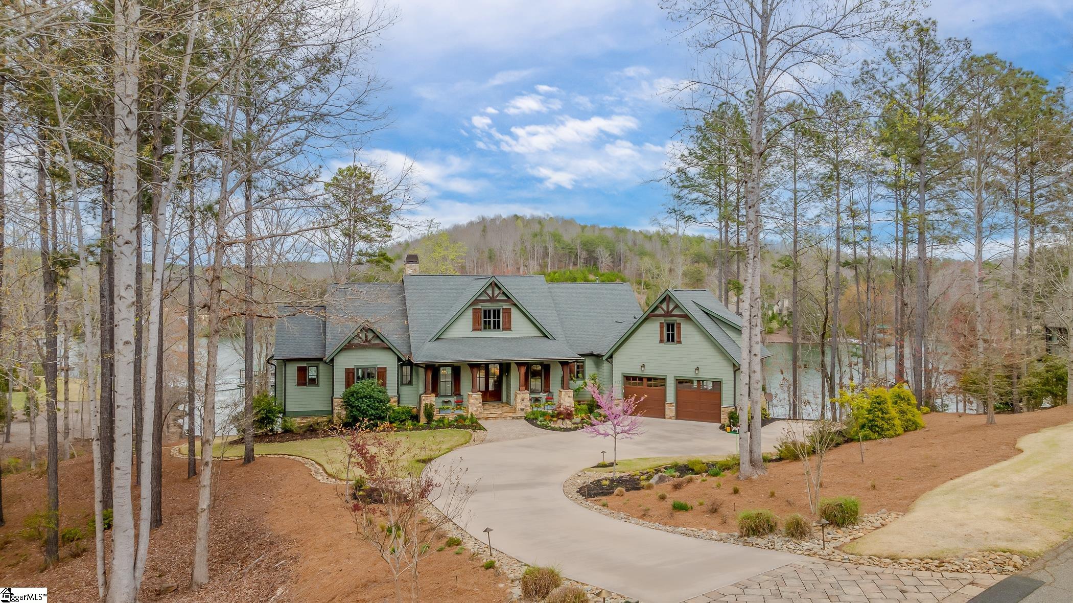 Immerse yourself in tranquility at your very own lakeside haven, located at 107 Mirror Lake Way. This exquisite 5-bedroom, 4.5-bathroom residence, custom built by Arthur Rutenberg, sits gracefully on a beautiful 1.67-acre corner lot within The Cliffs at Keowee Springs. Shielded by a natural berm, this retreat exudes a serene ambiance, along a natural woodland setting and manicured landscaped grounds. Upon entering, you're immediately greeted by breathtaking views that unfold before you. This open-concept layout effortlessly blends the great room, dining area, and kitchen, forming an inviting space ideal for hosting gatherings. Vaulted ceilings soar above, exuding a sense of grandeur, while rustic barn-wood accents scattered throughout add a touch of timeless charm. Yet, it's the expansive windows that steal the spotlight, offering enchanting glimpses of the serene lake from nearly every vantage point. The spacious gourmet kitchen with a wooden coffered ceiling includes all GE Monogram stainless appliances, a generous island with quartz countertops, and a full walk-in pantry. It combines style with functionality for all your entertainment needs. Step outside, where the screen porch and deck unveil an enchanting backdrop for outdoor gatherings, seamlessly blending the boundaries between indoor and outdoor living. Picture yourself on your deck, holding a cup of coffee as the sun begins to rise. The air is still and cool, promising a refreshing start to the day. Expandable glass doors effortlessly connect these spaces, inviting the beauty of nature indoors. Complete with a built-in Blaze BBQ grill and retractable screens, versatility and comfort are elevated, ensuring unforgettable moments with friends and family. In the master bedroom and bath, revel in breathtaking views of the lake. An additional upper level bedroom, boasting an en-suite bath and office area, awaits.  With the inclusion of a conveniently located laundry room, all your essential living spaces are thoughtfully situated on a single floor, ensuring seamless daily living. Descend to the lower level, where a wet bar and recreational room await, perfect for entertaining guests or unwinding after a long day. Discover three additional bedrooms on the lower level all with lake views; one featuring an ensuite bath, while the others share a bathroom, ensuring comfort for all. A spacious hidden workshop space adds versatility and can easily transform into a lake room for storing equipment and pursuing hobbies. Additionally, a sizable unfinished storage area offers ample room for meeting seasonal needs and storing belongings. Step onto the back porch, where you'll find a covered area perfect for smoking and grilling, as well as ample space for outdoor activities such as ping pong matches and games. A charming outdoor stone fire pit awaits, offering warmth and ambiance on cooler days while you soak in the beauty of the lake. With approx 220 feet of lake frontage, this property features a covered dock complete with a boat lift, water and electric utilities, and a Shock IQ electric safety system. Whether you're floating, swimming, paddle boarding, or kayaking within the cove, this location offers the perfect setting for family relaxation and water-based adventures. Come be part of the The Cliffs 7 communities and enjoy lake life at The Springs. You are close to all the amenities: pickle-ball and tennis courts, Tom Fazio golf course, new club house, fishing pond and dog park are a short golf cart ride away. A right to purchase a Cliffs Club membership is available.