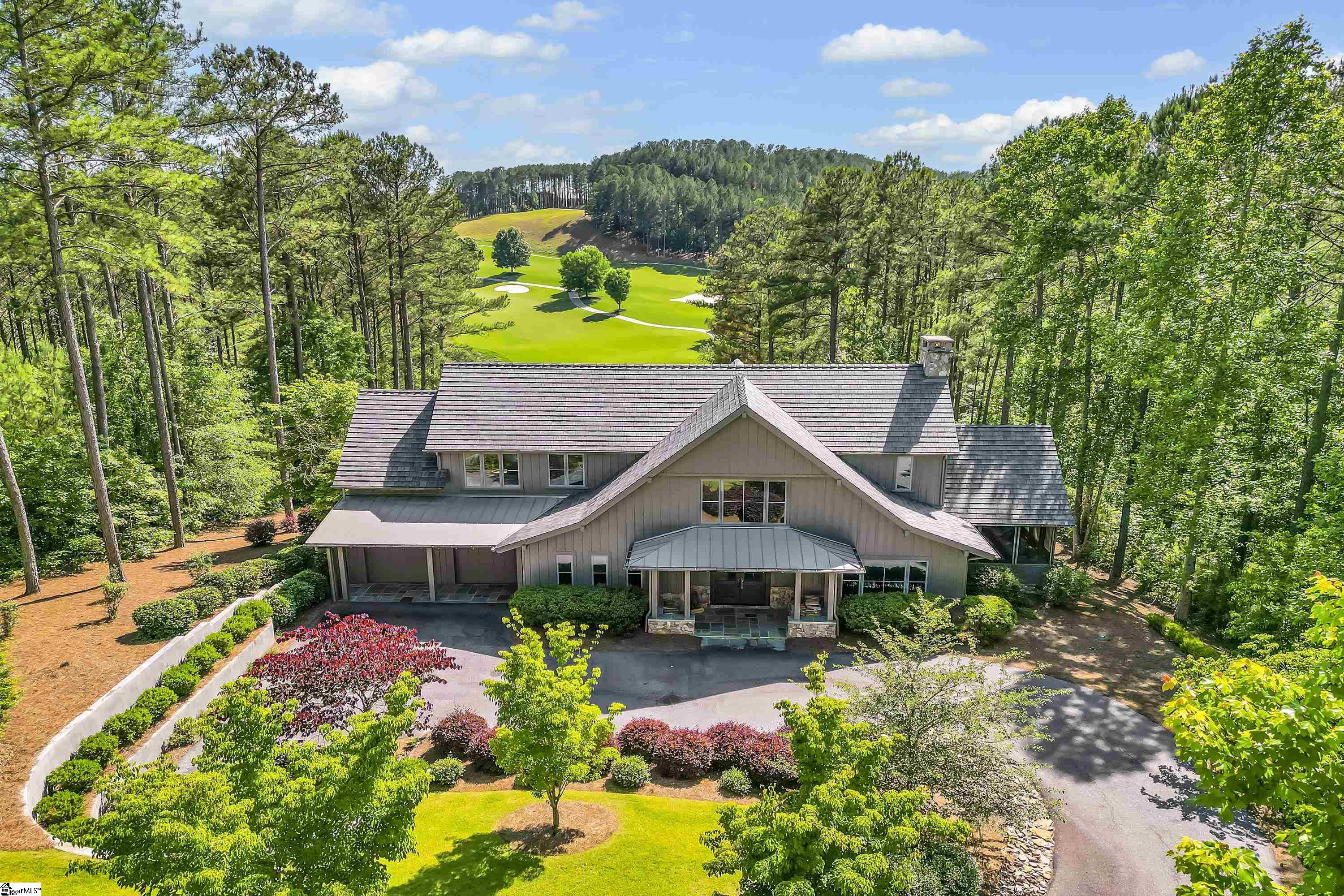 Located on a private cul-de-sac, this modern mountain/lake craftsman home was designed by acclaimed architect Jim Samsel and professionally decorated by interior designer Susan Nilsson. The property is meticulously landscaped with hearty, lush Zoysia grass and a thoughtful, natural-looking variety of redbuds, burning bush, and magnolias juxtaposed beautifully with ornamental trees and framed mature boxwoods. Board and batten and Hardie Board make for a durable exterior with a look of pastoral grandeur. Flagstone, granite stonework, and a newer DaVinci Black Oak roof contribute to a striking aesthetic established by the triangular architecture. The solid wooden double doors provide an expansive welcome while a subtle color palette paired with artful wallcoverings immediately gives you the sense you’ve entered a special space.Throughout the interior, there are wider plank oak floors and plantation shutters, and the home is equipped with surround sound. The well-appointed, open kitchen satisfies the chef in your life, and with two large islands, two sinks, a built-in microwave, a KitchenAid eight-burner gas range, and a wine chiller, it’s ideal for daily activities and epic entertaining. The kitchen opens to the den where a masonry wood-burning fireplace creates a cozy gathering place within an ample room with coffered ceilings.The pattern of the dining room’s coffered ceilings gives it a distinctive, modern flair. Located on the main level, the owner’s suite offers a stunning view of the 18th and 1st hole. The bathroom suite includes a Barclay Pilar acrylic oval tub with a Rubinet faucet—and the mirrors, lighting, and tile combination evoke tranquility. Across from the owner’s suite, you’ll find a laundry room with a large sink, two spots for folding, and generous cabinet space. Upstairs, there are three sizeable bedrooms with en suites featuring double sinks and lovely touches. Also upstairs is a private den/entertainment room for guests to enjoy or family members to utilize for an everyday escape. The amazing grounds include an outdoor kitchen, a terrace, a landscaped firepit area, and a screened-in porch. Find your perfect place to soak in scenic vistas of the golf course and the sunsets. The buyer is required to purchase a $72,000 premier membership at closing. The Reserve at Lake Keowee offers over $100 million in amenities, and recently announced additions include a 12-hole, par-3 course, sporting clays, plus new amenities planned with new ownership. This is your opportunity to own a truly remarkable retreat.