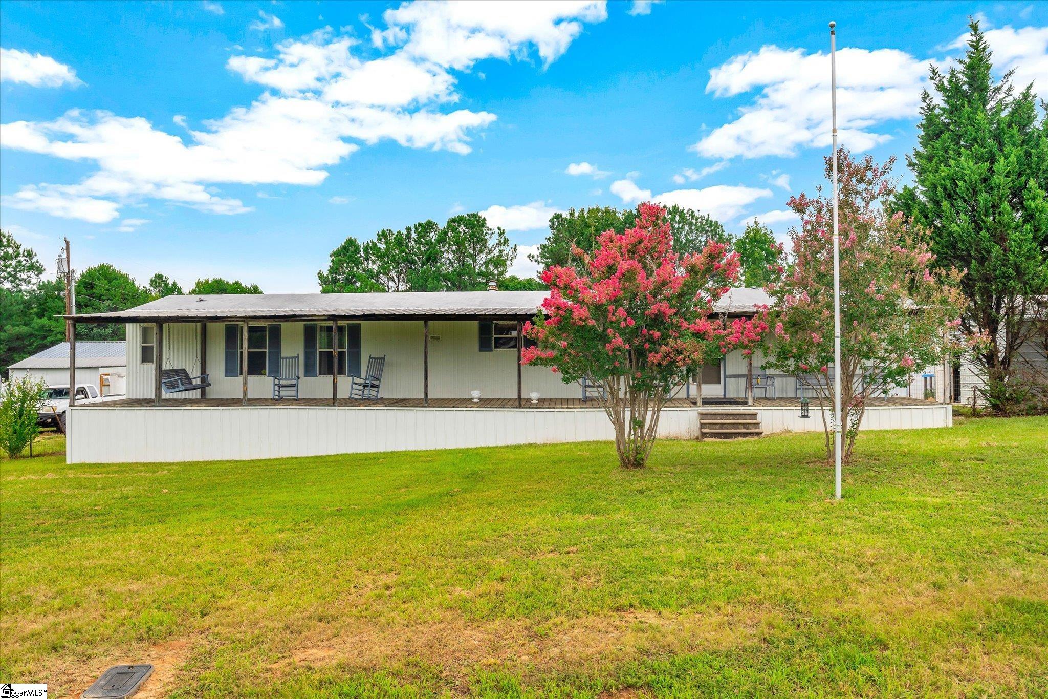 Well kept, one owner, two bedroom, two bath home, is ready for new owners to make their home.  This home comes complete with furnishings and all recently updated appliances, including gas range, dishwasher, washer, dryer, two freezers, and two refrigerators!  This lovely homestead has a large .60 acre lot with muscadine vines, chicken coop and room for a garden.  The gated fenced backyard has multiple outbuildings, for storage, work or hobbies and there's also a carport area for covered parking.  You will enjoy the huge rocking chair front porch (rockers remain) and back screened porch complete with outdoor furniture and a grill.  Homeowners added over 400 square feet of space for a mud room, a den, storage or hobby room.  This area of the home is cooled by a window unit air conditioner, but the rest of the home has a central heat and air unit.  Homeowners also state that electric was updated in the last year.  Come take a look at this home and make it yours today.   All you need is your suitcase to get you home to 106 K and M Farm Road!