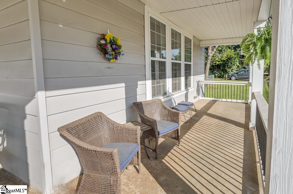 Triple windows overlook porch and street.  Screens on windows. Craftsman style front door.