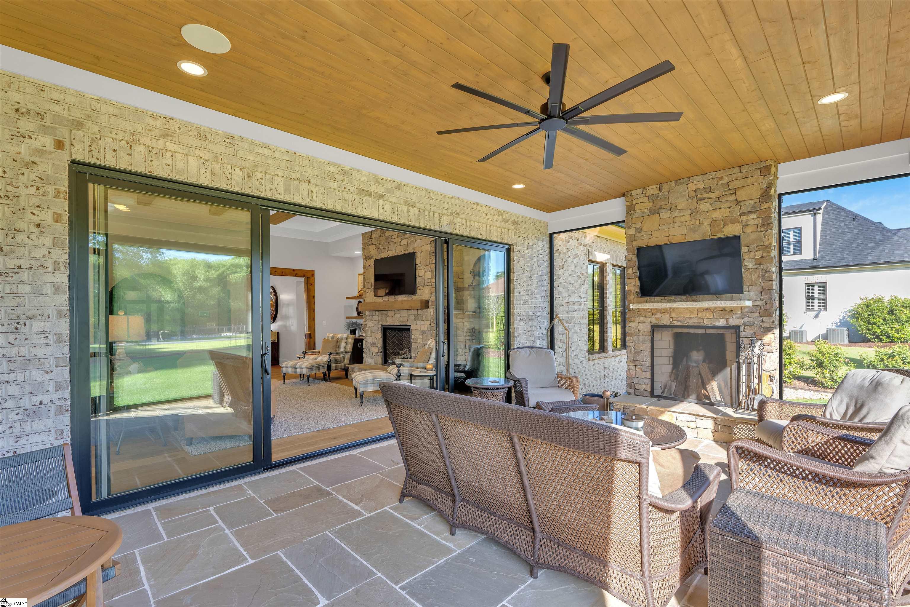 THE screened in porch featuring a wood burning fireplace with an electric starter and large 4-panel sliding glass doors.