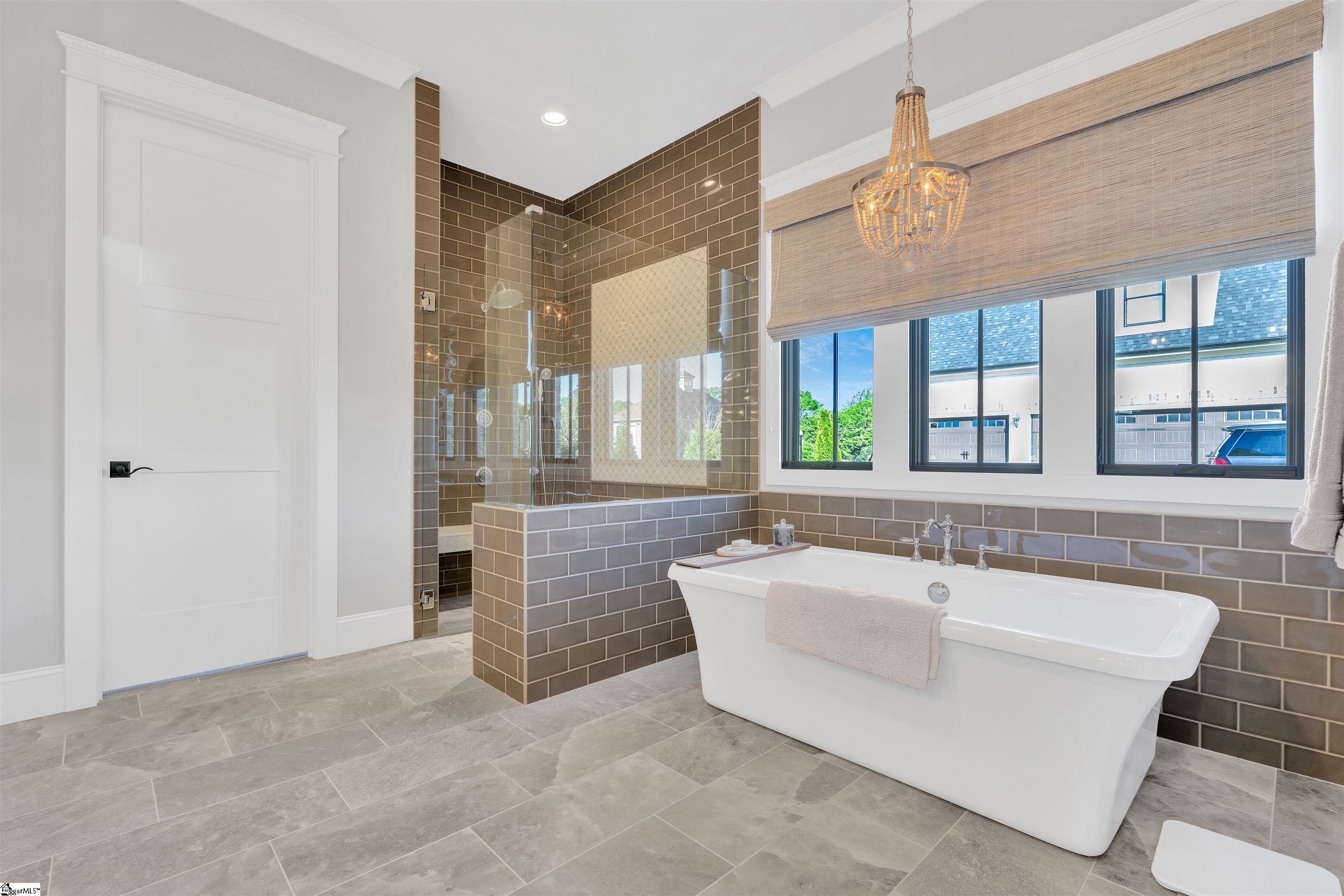 Primary On Suite with a custom tiled shower and soaking tub.