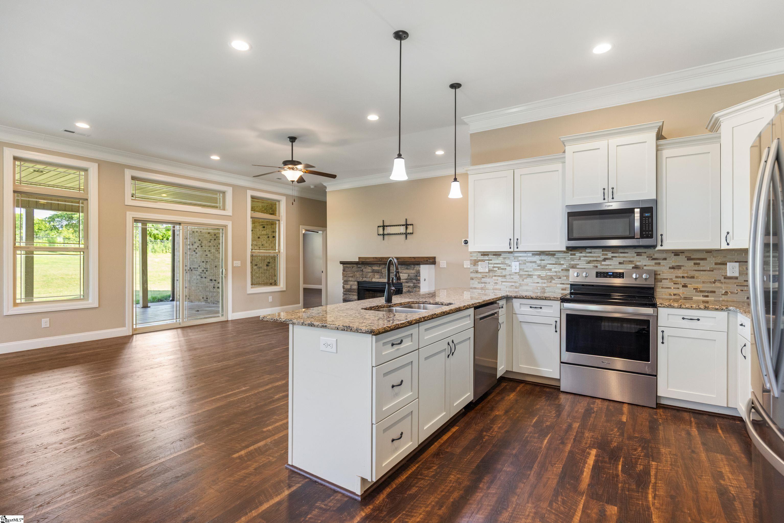 Kitchen featuring a convenient breakfast bar that opens to the spacious Great Room and Dining Area with access to back patio