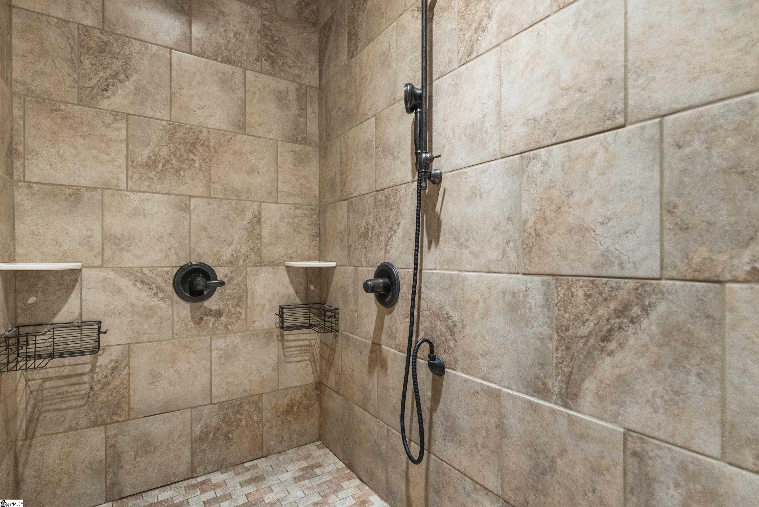 Spa-like en suite includes a walk-in shower featuring dual shower heads