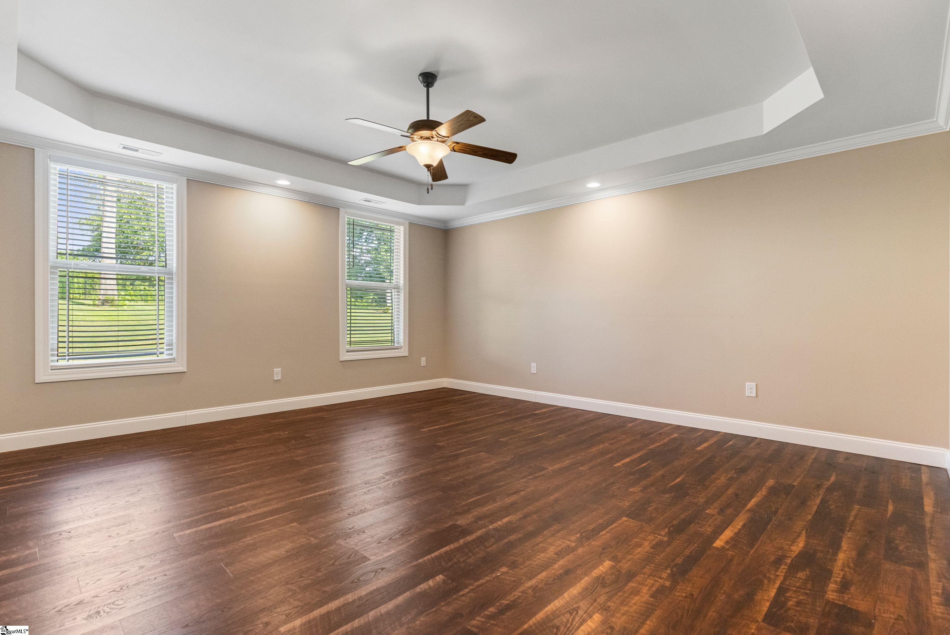 Serene primary suite featuring an elegant tray ceiling, generous space, and a peaceful ambiance—your perfect retreat at the end of the day.