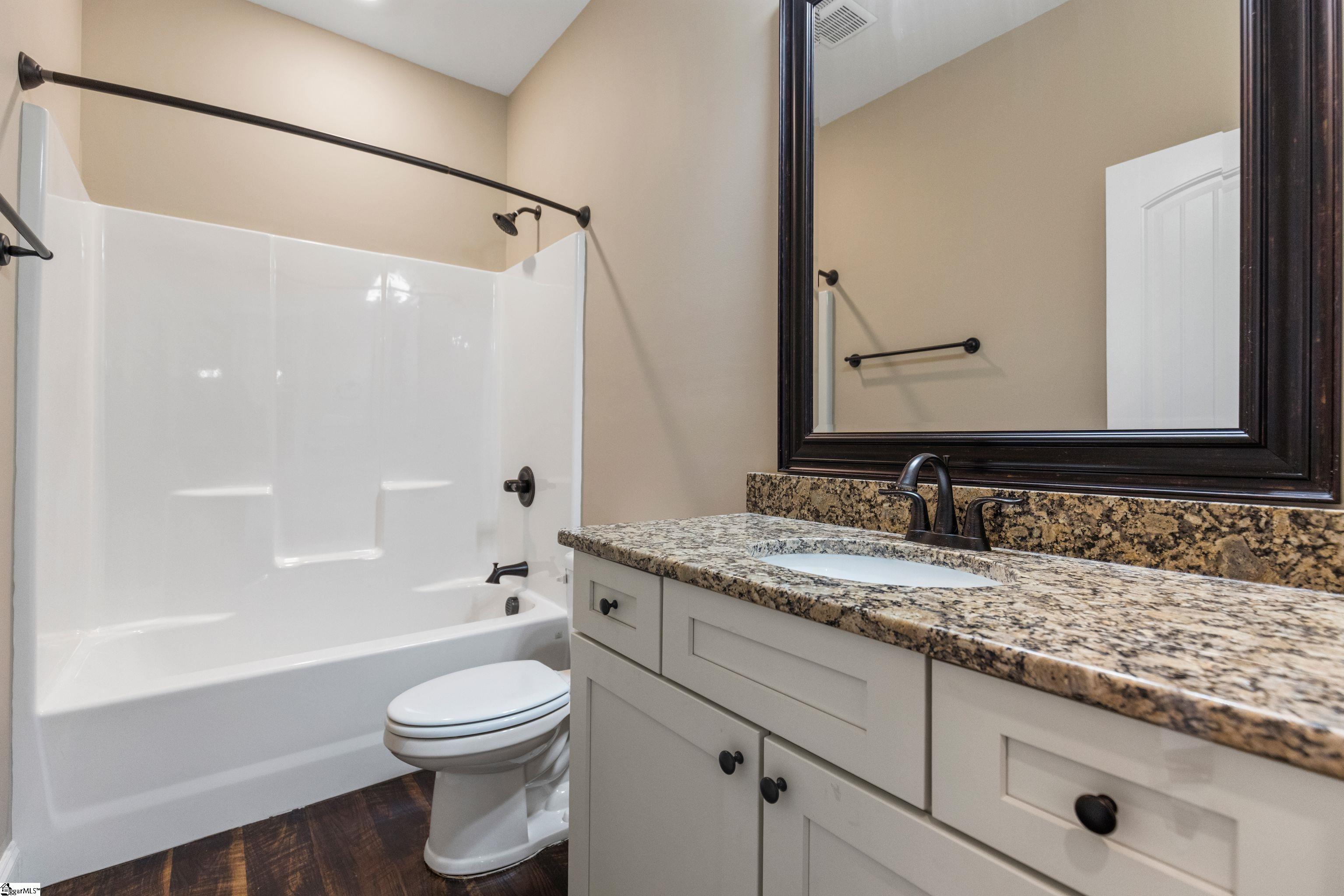 Well-appointed full hall bath conveniently located between the two secondary bedrooms and just off the foyer, featuring modern fixtures and neutral finishes