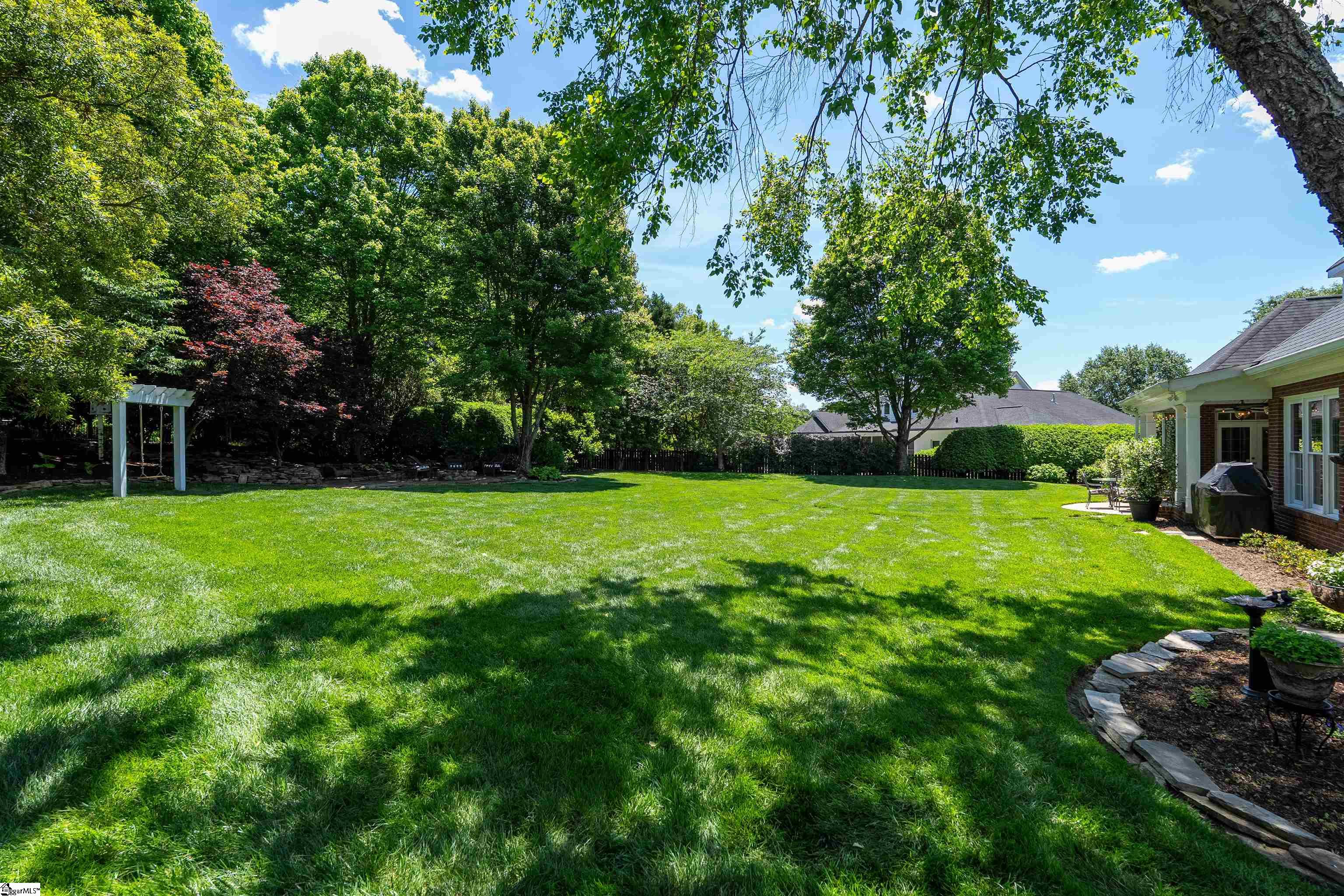 Level back yard with mature landscaping proving beautiful scenery and privacy.