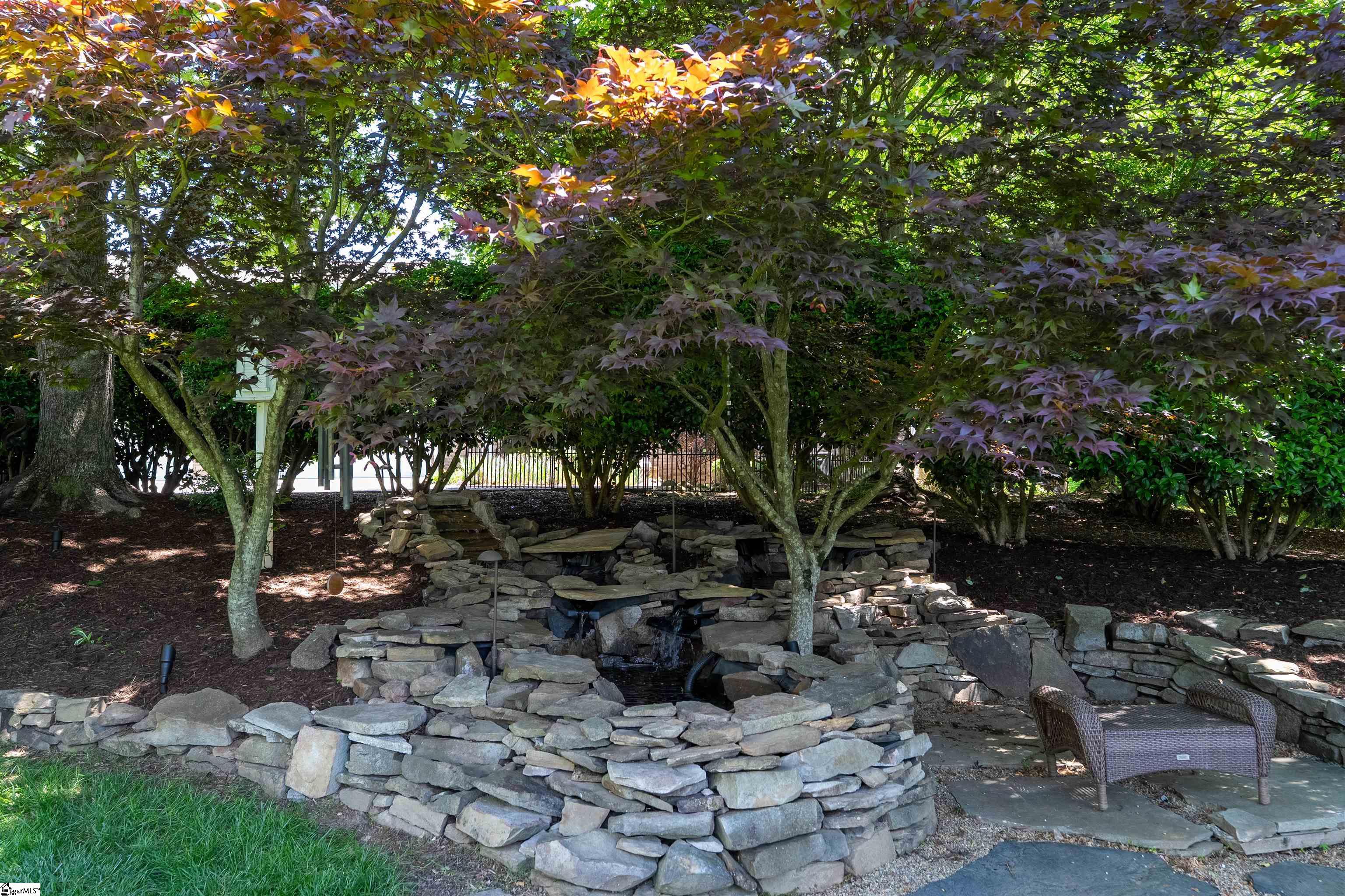 Remote controlled water feature provides soothing sounds adjacent to fire pit.