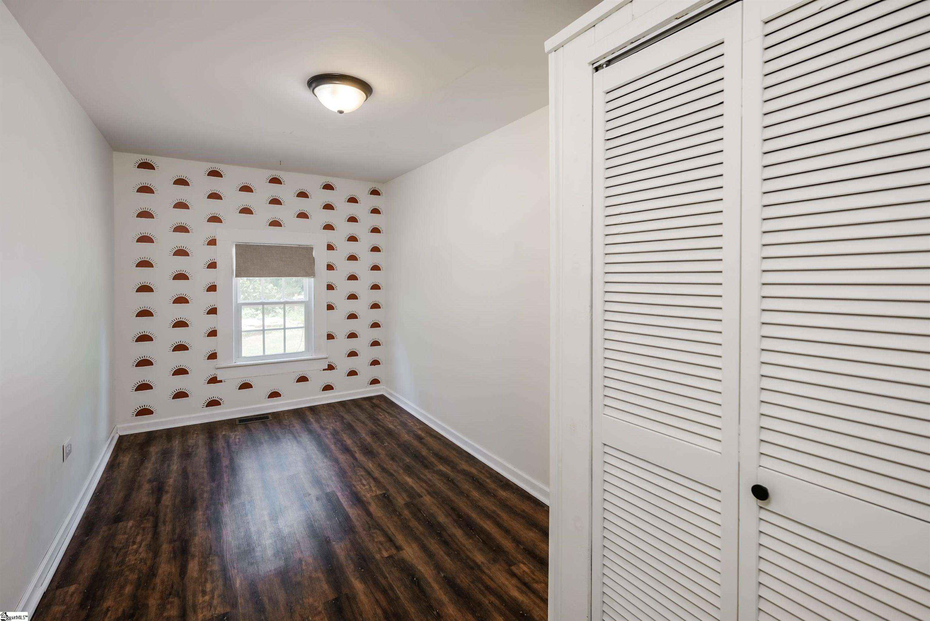 Second bedroom has stylish wallpaper feature wall. Perfect size for an office, guest room or nursery.