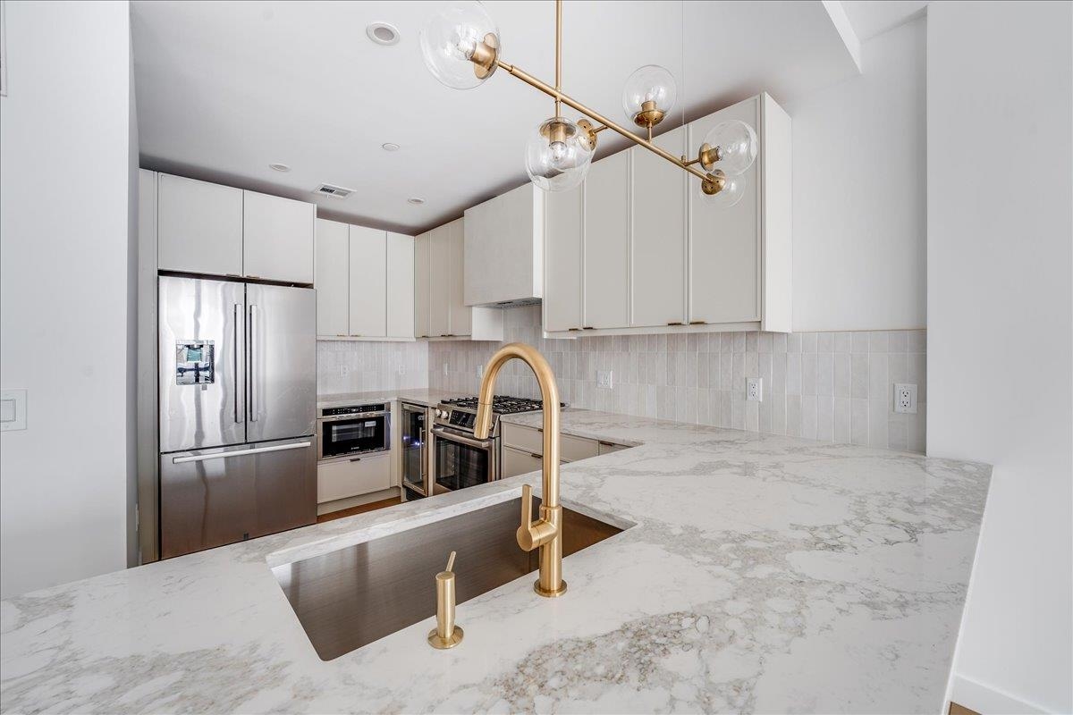 Welcome to Hoboken's Luxury Boutique new construction condos, featuring only four exclusive units. This residence offers 3 spacious bedrooms, 2 full baths, and 1, 381 plus sq ft of beautifully crafted living space. Built with concrete and steel for unmatched durability, these homes showcase an elegant brick exterior and a beautiful artistically plastered lobby. Designed by renowned interior designer LUMA, each unit exudes sophistication. The state-of-the-art kitchen is a chef's dream, equipped with BOSCH appliance package, wine fridge, and an under-mounted sink. The kitchen features stunning quartz waterfall countertops. Direct outside venting, under-mounted counter lighting, and LED lights complete the modern feel. Premium finishes include engineered hardwood floors, solid wood doors and Emtek hardware. The main ensuite bathroom along with main bathroom feel like luxurious retreat with quartz countertops. Each unit is enhanced with triple-pane German engineered windows, providing superior insulation and soundproofing. With east and west-facing windows, every room is flooded with natural light. Each condo boasts a private outdoor space: this unit features private backyard with built-in outdoor kitchen. The outdoor kitchen includes a gas fueled grill, fridge, sink, gas, and electric linesperfect for entertaining. Additional luxury features include a private elevator to each unit, washer/dryer in unit, a tankless water heater, and RHEEM heating and cooling systems. Moments from vibrant local dining, shopping, and easy access to NYC transportation, these condos offer the best of Hoboken living. Schedule your tour today!