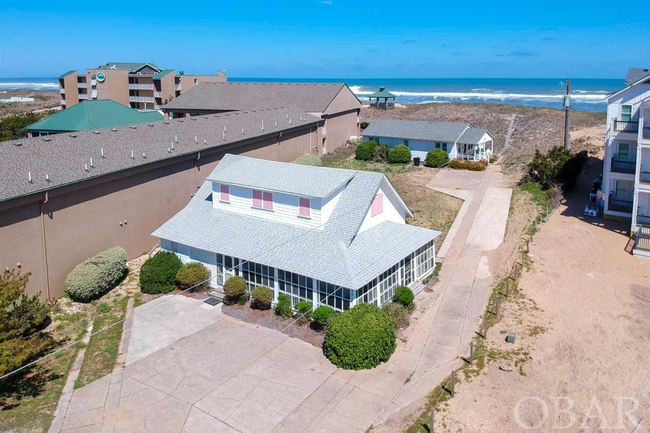 Rare opportunity to own a piece of the Outer Banks history.  According to the sellers, the front cottage named the "Ruth Cottage" was the boat house for the Lifesaving Station that used to be located in Kill Devil Hills. a few properties to the south.  When the station was decommissioned in 1933, the cottage was moved 100 yards north to where it sits now.  On the day the Wright Brothers attempted their first flight, the Surfmen from the Coast Guard Station helped the Wright's move their flying machine to the top of Kill Devil Hill.  It is safe to assume that the Wright Brothers have been inside of this cottage.  The back cottage closest to the ocean was located from the Naval Shipyard in Norfolk and was used to house families on the base during WWII that were building ships during the war.  In 1950, the current sellers family bought the property and it has been in the family ever since and they would love to see it preserved for generations to come.  If you are interested in utilizing this large prime oceanfront lot for new construction, you will have endless possibilities that could result in a great investment property maximizing rental income.  This location is next to a lift station so you should be able to tie into the central sewer which will allow you to build a large house.  Please ask listing agent for plans and rental projections for new construction.
