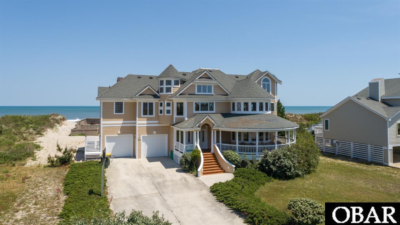 GORGEOUS, UNIQUE HOME WITH THE ATLANTIC OCEAN AS ITS BACKYARD!  This is such an awesome opportunity!  A home like this doesn't come available often.  Very well loved over the years, the owner has taken great care to get it ready for its new owner - it is in exceptional condition! The foyer invites you in as you enter the home.  Immediately move upstairs to find the great room with expansive views offered by the 2 story wall of windows!  Hardwood floors, dining with those continued ocean views, spacious kitchen with an absolutely charming breakfast nook and a cozy sunroom off the kitchen make for a perfect living area.  The master suite is on this level with more ocean views, 2 sided fireplace and a large private deck.  You'll find 3 more bedrooms on the entry level, 2.5 bathrooms and a large den.  Huge covered porches complete this level offering lots of space to relax.  Moving back upstairs and take the spiral staircase from the living level up to a wonderful loft retreat with so many options - more sleeping space, office, exercise room, kids game room - and of course the ocean views are amazing from this level!  The outdoor living space this home provides is phenomenal!  Expansive sun decks, covered decks, large poolside patio, dune top gazebo and even another deck right next to the beach!   Another feature of this home is the huge 2 car garage which is hard to find - so convenient for you and your guests!  Located in Whalehead which is a wonderful community with large homesites and beautiful wide, flat beaches.  The Corolla bike path runs along the community taking you to Timbuck II Shopping Center, the Food Lion Shopping Center, The Currituck Lighthouse, Whalehead Club, Historic Corolla Village and so many amazing restaurants and shops!  Many of these are within biking distance!  Again, this is truly a one of a kind opportunity.  An extremely well-maintained, charming, not-your-typical beach house, home!