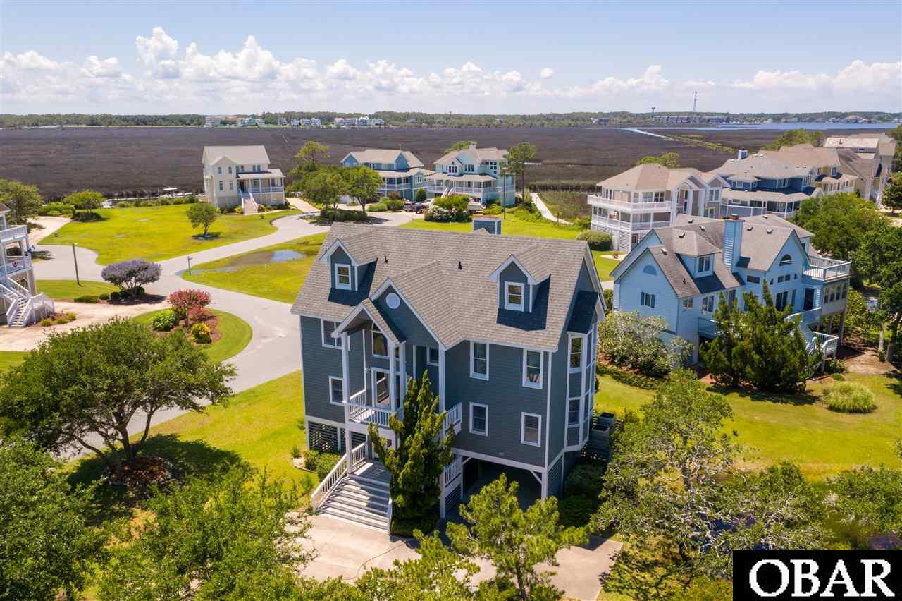 CANAL FRONT 3 STORY HOME IN PIRATE'S COVE WITH 55' BOAT SLIP!  NEW Flooring being installed in Living and Dining area, and you will swoon over the gorgeous NEW KITCHEN with Stainless Appliances, Granite Counters, and a Tiled Backsplash in cool coastal colors!  3 Bathrooms are also getting NEW Vanities and the same LVT flooring that is in the Kitchen (Feb. 2020)!  The home itself sits slightly back from the water, keeping it more protected, but still offers waterfront living on a protected Canal, water views, and a private boat dock...the best of both worlds!  Details including Hurricane Shutters, Cypress Ceilings, Cedar Lined Closets, Hardwood Flooring, Outside Shower, tons of Outdoor Decking for entertaining, and a Circular Driveway make this home a dream.  Enjoy Canal and Marsh Vistas from the reverse floor plan Living, Dining and Kitchen on the top level.  There is also a Master Suite and spacious en-suite bathroom on the top level along with a Screened-in Porch and wrap around Sun Decking.  The mid level boasts 3 additional bedrooms, including a 2nd Master Suite, a large Laundry room, and Covered Decking.  The ground level offers a carport with dry entry and a storage room.  Not to mention all the amenities Pirate's Cove offers including a Clubhouse, Fitness Center, 2 Community Pools, Playground, Gated entrance with Security, and a Community Pavilion!  Hammock Village offers LOW HOA dues at just $1700/year!  You can also enjoy easy access to some of the best fishing spots on the Outer Banks and are close to downtown Manteo with its gorgeous waterfront boardwalk, shops and delicious restaurants! Recent Updates and Improvements include: NEW Stairway Carpet 2020; NEW Roof 2017; NEW Exterior Paint 2017/18; NEW Carpet in both Master bedrooms 2017; NEW HVAC (upper and lower, compressor and condenser units) 2013/2015 respectively; Some/Most NEW Anderson windows throughout the home and ALL sliders replaced 2014.