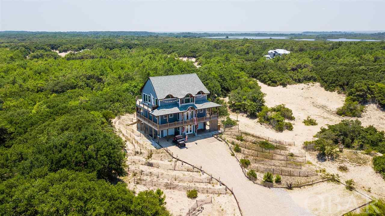 Beautifully Sublime, Extremely Private 10 Acre Oasis with Very High Elevation in a Peaceful Maritime Forest of Majestic Live Oak Trees and Wild Mustangs in the Four-Wheel Drive Area of the Secluded Dunes on the Pristine North Swan Beach in the Outer Banks. Magnificent Awe-Inspiring Property and Unobstructed Stunning Views with a Large Clear Pond, Large Secluded Pool House and Gorgeous Home Built to the Highest Quality, Strength and Functionality Designed to fit into the Environment with Environmental Conservation and Weather a Design Priority. Home Designed with Exquisite Architectural Details and Sophisticated Modern-Day Technology to Maximize Passive Solar Energy Including Extra Large High-Quality Windows and 8 ft. Glass Doors Which Bathe the Interior W/Natural Sunlight Adding Serenity to the Space. Completely Custom Main House and Pool House 100% Sourced by Owners and 100% of Construction Performed in Owners Presence to Ensure Complete Oversite to Sensibly Build to the Highest Quality Possible. Every Single Aspect of Building and Sourcing this Home was Diligently Investigated to Determine the Best Possible Practical Architecturally Pleasing Building Solutions and Goods Available.   Main House 3,951 SqFt, 282 SqFt Garage, 4 Bedrooms, 4 1/2 Baths. Pool House 477 SqFt, 1 Bedroom, 1 Full Bath, Shower and Changing Room.   4,731 Total SqFt Outside Decking.  Intricate 143 Foot, Stepped Walkway, Built Entwined Around the Live Oak Trees Up and Over the Dunes from Main House to Pool House.  House Features Include: Super Strong Custom Built 2 X 6 Home and Pool House.  Open (Acrylic Walls and Ceiling) Elevator. Extra High Ceilings including Top Floor 17 Foot Vaulted Ceiling. All Doors are 8' Solid Core. Modern Innovative Electricals and Lighting to give the Rooms Soft Calming Indirect Mood Lighting and Wall Wash. 8 ft. Casablanca Fans and Big Ass Fans. Custom Made Powder Coated Railing and Elevator Doors. Highly Polished Cement Ground Floor and the Balance Solid Oak Flooring. Marine Grade Stainless Steel 316L Wire Cable Railings Inside and Out. Two Master Bedrooms Featuring Restoration Hardware, Johnathan Adler and BioConcept Furniture Sets and Extra Large Walkin Closets. Two Master Bathrooms with Free Standing Soaking Tubs, Walk in Showers and Top of the Line Faucets, Accessories and Lighting. Gourmet Kitchen Features Extra Tall White Lacquer Kitchen Cabinets and Top of the Line Energy Star Stainless Steel Appliances by Subzero, Wolf, Marvel, and Miele. ALL Custom-Made Cantilevered Concrete Counter Tops in Kitchen, Bathrooms, Laundry Room, and Office. Double Sink in Master Bath One Incorporated into Countertop. Custom Concrete 14 Seat Dining Room Table. 32KW Whole House Generac Generator with Automatic Transfer Switch and Ingersol Rand High Performance Air Compressor. Highly Sophisticated House Water System to Provide the Optimum Cleanest High Pressure Water. Infrastructure Installed for Future Extra Bedroom and Systems (ie. Solar, Electrical Systems and Equipment, and Water Storage). Automatic Hydraulic Gated Compound W/Remote Access. Security Camaras, Thermostats, Music/Home Theater Systems and Landscape/Pegoda Lighting Smart Phone/Tablet Controlled and Reviewed. WiFi Boosters, Backup Satellite Internet and Complete Office Setup. Extremely High Quality and Powerful Denon Receivers, Amplifiers and Speakers.   Pool House includes: Bulk Headed 20,000 Gallon Heated Salt Water Pool W/Raised Decking and Many Extras. Pool House Opens to Covered Deck W/Two Eight Foot Powder Coated Glass Garage Doors. Twenty Foot Continuous African Mahogany Bar, 8' Stainless Steel Lynx Grill and Solid Buffed Teak Outdoor Furniture.   Many Extras too Numerous to List.  Meticulously Maintained W/Complete Attention to Detail.  Property includes a 2008 Toyota Tundra, a 2013 6X6 Polaris Ranger 800 and a 2017 Kawasaki 4x4.  Copy/Paste to view the virtual tour: http://bit.ly/405BrattenWayTour