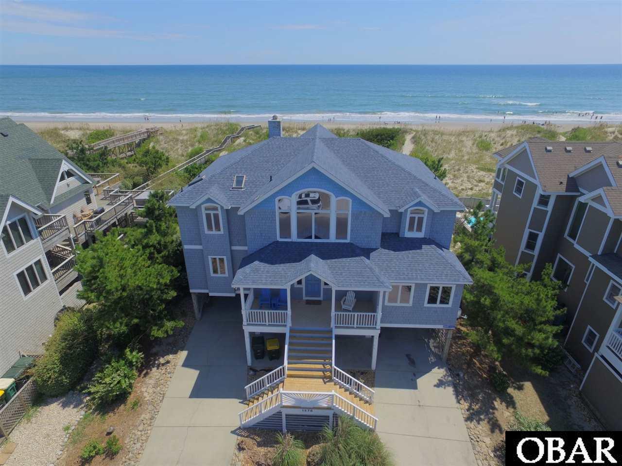 Wonderful OCEANFRONT home with STRIKING OCEAN VIEWS GALORE.  This home is SPACIOUS, living large and sleeping many with 3 large KING MASTER ENSUITES  & 1 Large Bedroom with 2 Queen Beds, all with ocean views. The 5th bedroom hosts a pyramid bunk set and a charming twin 'boat bed' for the little ones.  The top floor has an open-concept featuring CATHEDRAL CEILINGS with FLOOR-to-CEILING windows, built-in cabinetry, a gas fireplace and hardwood floors. Enjoy water views from the kitchen with sparkling GRANITE countertops, ceramic tile and while dining. You'll MEDIA ROOM with Home Theatre System and the Game Room featuring a pool table, wet bar with mini-fridge and 2 Full-sized Futon beds. Situated on very high lot with wide beach, relax in the oceanfront hot tub and enjoy the 16'x32' HEATED POOL and PRIVATE POOL DECK. Located at the north end of Route 12 where nature takes center stage, The Village of Ocean Hill offers opportunities for family fun, sport, recreation and sheer relaxation. Within the community you'll find two swimming pools one which is oceanfront and provides access to the beach and is adjacent to the FITNESS CENTER and snack bar. Additional amenities include a Basketball court, a Sports Court, two Tennis Courts, and enjoy the nearly 2-mile stretch of newly paved bike lane which connects VOH to the shops and community of Corolla Light for shopping and dining! Sellers have re replaced the polybutalene pipes and cooktop range in kitchen.
