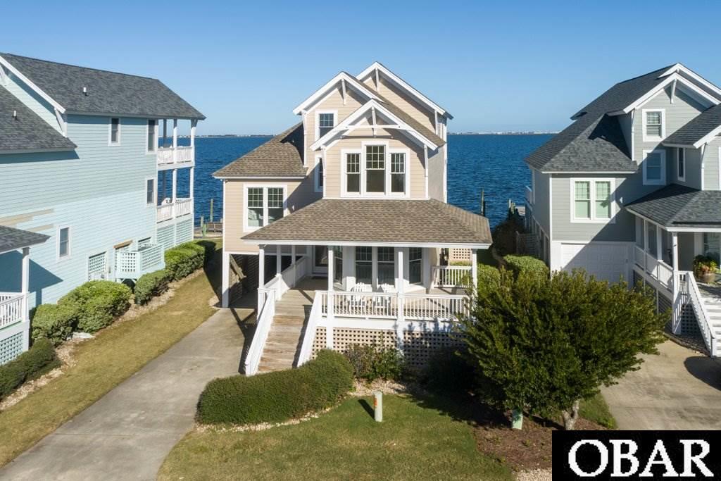 Beautiful SOUNDFRONT property located the Pirate's Cove Village Landings subdivision.  This 2,204 HSF home was designed with an open floorplan with CATHEDRAL ceilings, 9FT ceilings, gas fireplace, master suite with private balcony and bedrooms on every level.  SOLD FURNISHED, this 4BR, 3BA investment property boasts a solid rental history and is located in an X Flood Zone, BULKHEADED lot with a private pier and 30FT boat dock (slip 68) that conveys to a qualified boat owner.  Relax in the NEW hot tub or enjoy the 180 degree water views from the bi-level decks or fish off your private pier. This custom-built home is nestled in the heart of Pirate's Cove and community amenities include: swimming pool and clubhouse, tennis courts, renovated fitness center, commons area, playground and miles of perimeter docking perfect for walking or accessing the sound waters.  Drive your golf-cart to our world-class fishing marina or enjoy our on-site restaurant.  Sellers have invested @$70K in repairs/refurbishments.  New Roof 2018.