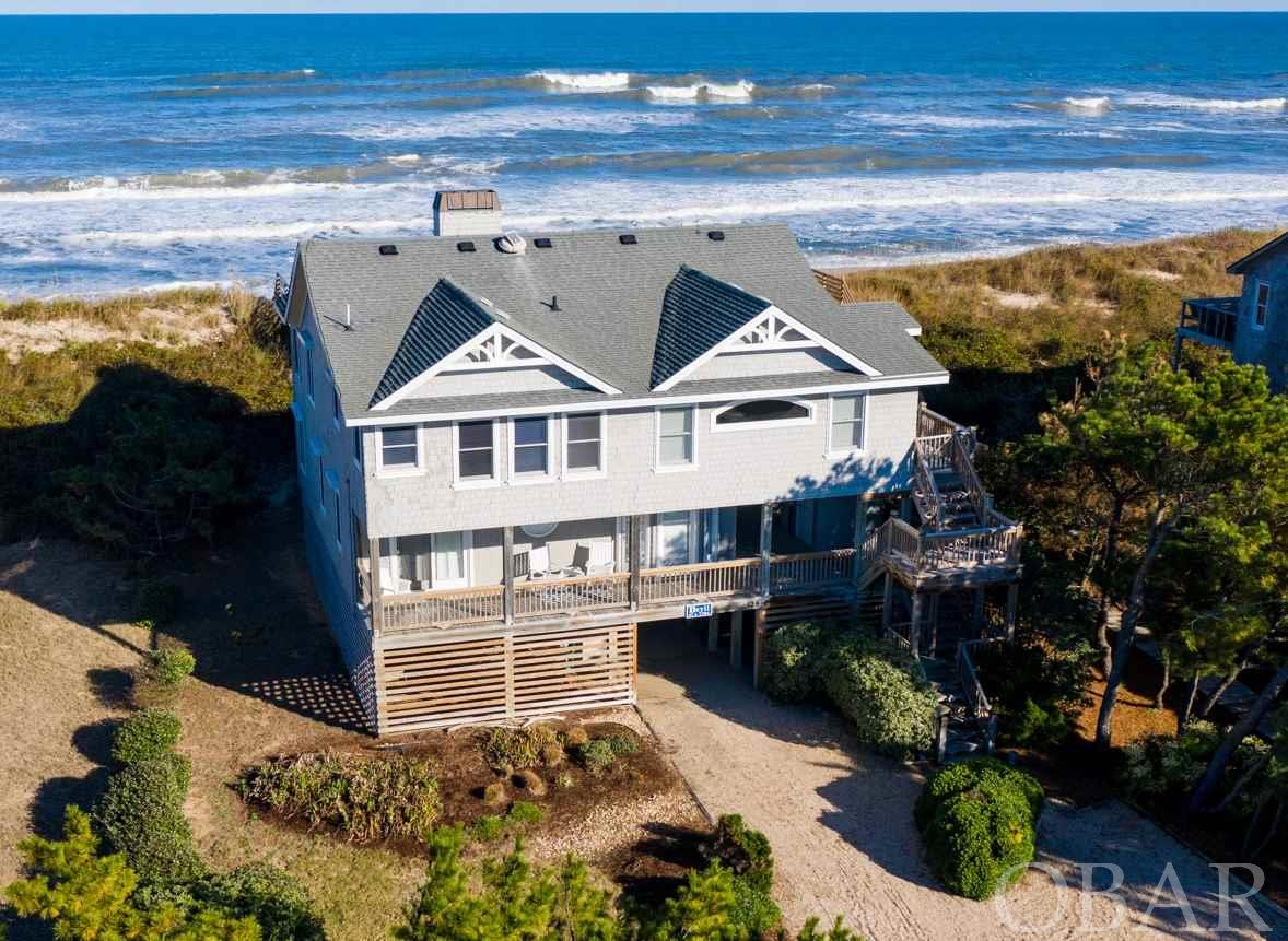 You will not want to miss this gorgeous, totally updated five-bedroom, four bath Sanderling oceanfront home! Amazing views of the ocean, very light/bright and open with beautiful décor and furnishings, you won't need to lift a finger at this stunning property, which has been lovingly maintained in turn-key condition. The top floor boasts a large, updated kitchen with new quartz counters, tile floors, plenty of cabinets, and new appliances. Spacious dining area where you can take in the fantastic views while enjoying a meal. Wood-burning fireplace with a lovely white brick, high beamed ceilings and plenty of room to spread out with comfortable living area seating as well as a sun room area and bar top table for enjoying your morning coffee watching the sunrise over the ocean. There is a huge king bedroom located on the top floor with a beautiful updated bathroom with dual vanity, tile floor, and custom shower with glass door. Enjoy the ocean breezes and soak up the sun on the large, expanded, new decks facing the ocean and wrapping around the south side for more sunshine. The mid floor boasts yet another area to lounge, watch TV, or just kick back and relax. Even more decking for relaxing in the shade or snoozing in the hammock. Four large bedrooms with three fully updated bathrooms located on this floor complete with a suite that can be closed off for more privacy. There is also a private office located on this floor with a sleep sofa. Wood floors, fresh interior paint, nicely landscaped, updated furniture, roll down storm shutters (new in 2020), and even an elevator! This is currently a great rental property but would make an ideal second home too. Plenty of storage, outdoor shower, nicely landscaped with great curb appeal. Take the private walkway to the beach (redone in 2018) so you can enjoy the quiet, uncrowded beach, all in your backyard! Walk to the Sanderling pool and tennis facilities, and even bike or walk into Duck Village in just minutes, where you can enjoy the wonderful shops and restaurants Duck has to offer. The Village also has a town park, playground, and sound-side boardwalk, great for launching kayaks and paddle boards. This property is an absolute gem! Be sure to view the virtual tour by clicking link or cut/paste into your browser: https://my.matterport.com/show/?m=WjpjCq7jQqM&mls=1