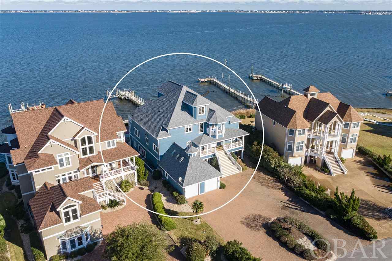 Immaculate Soundfront home with Boat Lift!  Located in the Ballast Point subdivision of Pirate's Cove, this 8BR, 7 Bath, 2 partial bath home was designed to showcase the 180 degree water views and features soaring ceilings, gourmet kitchen, dining room with separate breakfast nook, two master suites, roomy den/office, a lower level game room and family room, wine cellar, entertainment loft, and bi-level decks that overlook the heated pool, hot tub and private pier with boat Lift.  SOLD FURNISHED, this potential investment property features Brazilian hardwood floors and spiral staircase, tumbled marble foyer, Thermador kitchen appliances, NEW sub-zero refrigerator, granite countertops, tile surround walk-in showers, 4 gas fireplaces, elevator, two wet bars, two laundry rooms, a tackle room, outdoor shower, and 2 car garage with separate golf cart garage.  In addition, a 35FT boat dock (slip 33) in the Ballast Point canal could be assigned by the HOA to a qualified boat owner.  Located in the gated community of Pirate's Cove, community amenities include two swimming pools, tennis courts, clubhouse, renovated fitness center, playground, commons area, world-class fishing marina, on-site restaurant and 4 miles of perimeter docking perfect for walking or fishing.  NEW roof Oct. 2018 & NEW Exterior Paint 2019, Interior paint 2020.