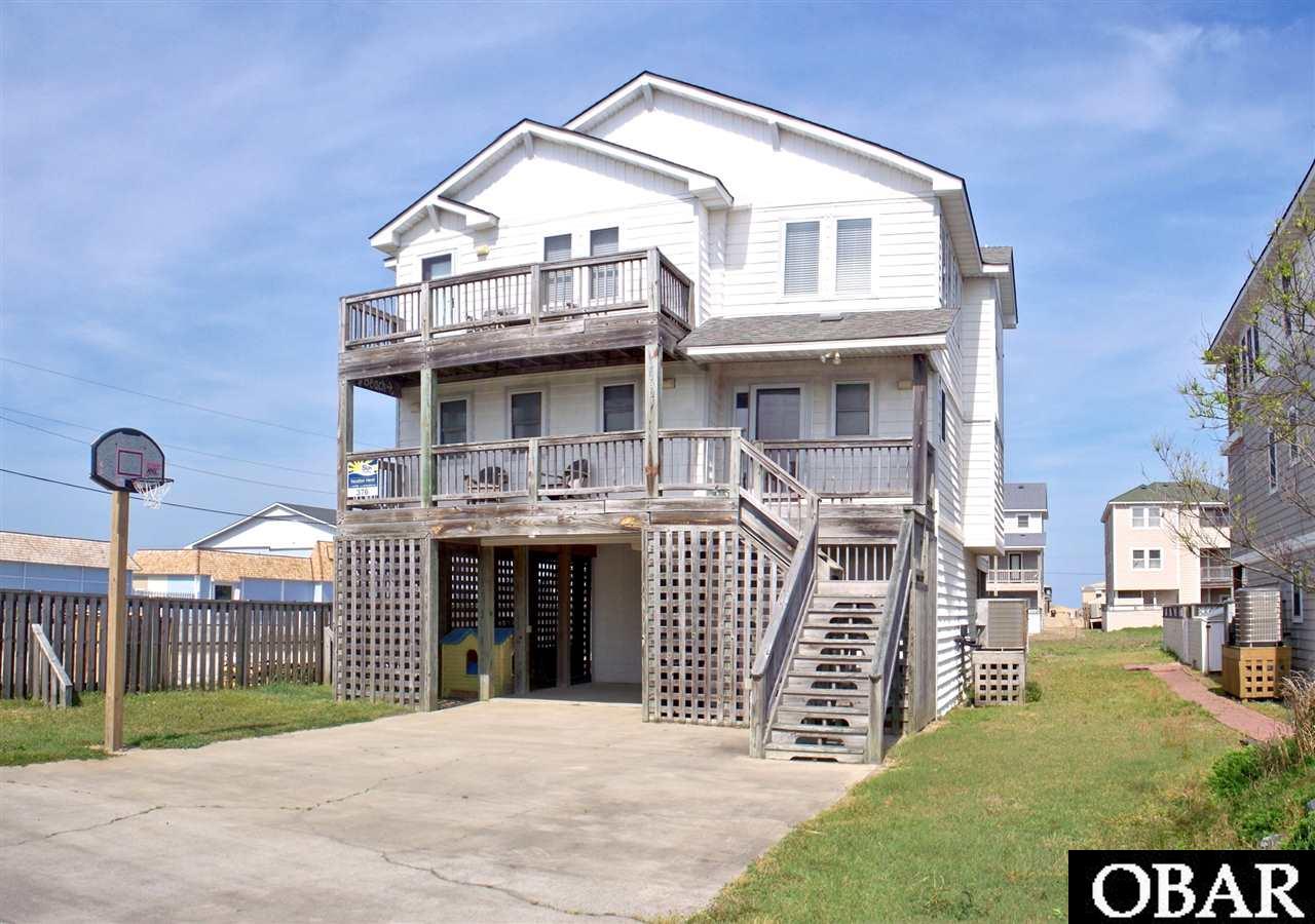 Lustrous new granite kitchen with white cabinets, stainless appliances and attractive ceramic flooring in kitchen and dining room!  This cottage has every hot button item that vacationers desire: Ocean views, public beach access just 200 feet away, convenient elevator, en suite bath for every bedroom, ground level game room with full bath and easy access to private pool and hot tub.  Reverse floor plan provides water views from deck and dining area. Great room has juniper wainscoting, gas fireplace with built in shelving, and access to westerly deck.  Central location is close to dining, shopping, and some of the widest beaches on the Outer Banks.  Back yard has just been fenced in, providing a play area for lawn games.  Solid rental numbers, with more capability by extending spring & fall rentals, plus peak season weeks currently used by Sellers.  Buy now, and let the cash flow into your pocket!