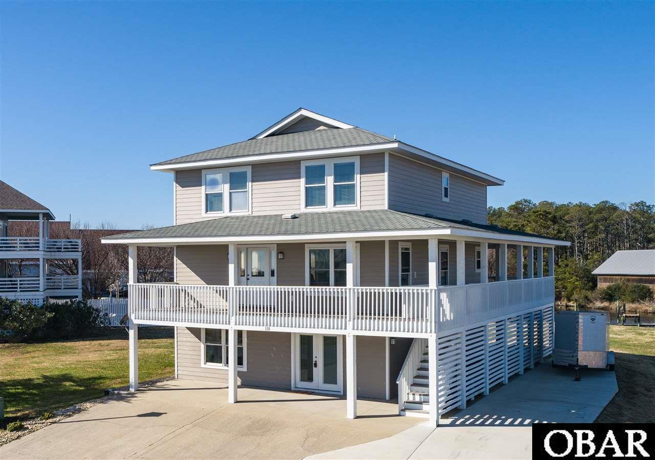 Immaculate canalfront home!  Nestled in the coveted Peninsula subdivision of Manteo, this boater's dream boasts multiple renovations/updates.  Designed with a traditional floorpan, this home or potential investment property boasts an upper level master with luxury bath with dual vanities and added stand alone tub, two guest rooms with full bath, adjoining mid-level living rooms, kitchen with eat-on bar, and dining area that opens up to the wraparound porch that overlooks the conveying stern-2 slip that accommodates up to a 40FT boat.  The spacious lower level offers a cozy living area with bedroom and full bathroom, storage room, and tackle room  Since purchase, this property has received meticulous attention from its owners with the following improvements:  NEW LVT flooring in all main living areas, all NEW furnishings, NEW decor/artwork, NEW stainless appliances, NEW plumbing, light fixtures, and ceiling fans, NEW Rinnai tankless hot water heater, NEW ceramic tile flooring, added exterior rear decking/steps and plumbed for an outdoor shower.  Located on a roomy lot, this property has location value and enjoys close proximity to downtown Manteo and area attractions.  Private HOA boat ramp is located across the street.  See associated docs for list of improvements.
