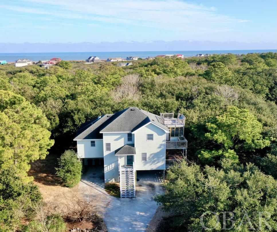An opportunity to own so close to the beach in Chicahauk rarely comes along! You'll love the quick trip to the lifeguarded beach access! 5 bedrooms with 4 1/2 baths in one of the most coveted communities on the Outer Banks. Situated in an X Flood Zone on a huge 28,000+ square foot lot adjacent to the community's private green space, the expansion opportunities are endless and peaceful privacy is priceless! Perfect for year-round lifestyle or utilize as a second home/investment property for additional income. The home boasts a wonderful spacious floor-plan perfect for spreading out and entertaining with an abundance of natural light and bedrooms on all 3 levels including 2 Master Bedrooms Suites. Spacious open Kitchen, Dining & Great rooms with gas fireplace lend access to a sun deck, rooftop deck or screened in porch for relaxing. Chicahauk features nature trails, bike and walking paths to your choice of nearby restaurants, shopping, specialty stores and more. Join the Southern Shores Civic Association and enjoy Soundside Marinas with boat launches, picnic/fishing/crabbing areas, Sound front Beach, additional Private Beach accesses, parks, basketball and soccer field. Recent Improvements include improved septic system to accommodate 5 bedroom (2020), New HVAC unit (2020), New Exterior Paint (2017). You're going to love it! Schedule your tour today- it won't last long!!