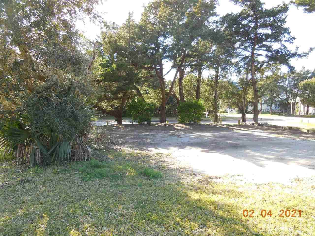 A beautiful lot on Old Beach Road! This property is a part of the new Live Oak Village subdivision. Lovely trees and native vegetation. Great location for walking or biking to island activities or hop on the tram to visit the island shops and restaurants. This property conveys with a 4 bedroom septic permit and a 3 bedroom/2 bath water meter. Restrictive covenants in place to retain the historic charm and quaintness of Ocracoke. Choose from several classic coastal home designs! Taxes are an estimate only. Currently being taxed as one large parcel.