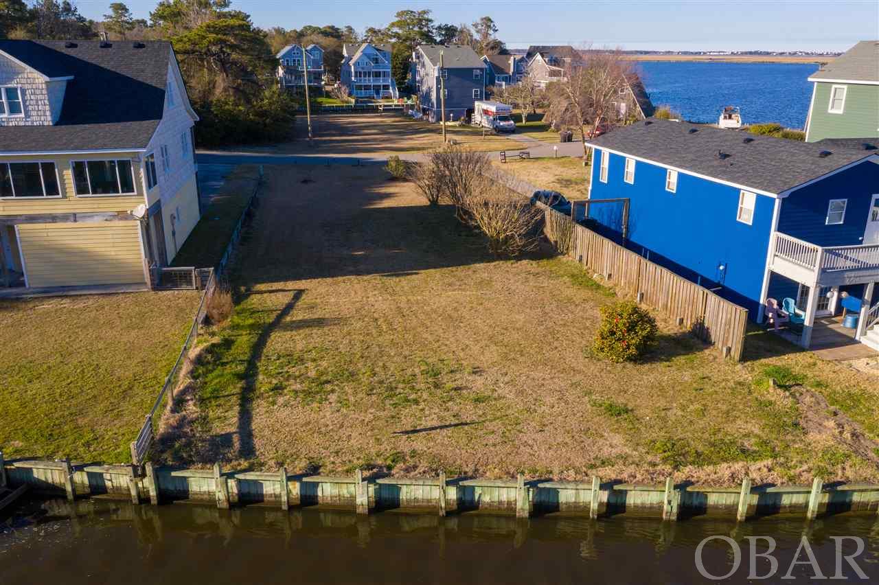 REDUCED!!!! BRING OFFERS!!! Wonderful CANAL FRONT homesite in the boating community of Colington Harbour!! 62 FEET OF BULKHEADED WATER FRONTAGE! Fantastic LEVEL & CLEAR, READY TO BUILD - southern exposure site!! Enjoy gorgeous water views of both Brigantine Inlet and the lovely Colington Bay and savor the stunning morning sunrises!! Build your dream home and enjoy this water lover's paradise! Colington Harbour community amenities include:  Clubhouse, marina, dock w/boat ramp, Olympic size salt-water pool, baby pool, sound front park area w/swimming beach & tennis courts. This site is located two streets past the security gate of Colington Harbour on Queen Ct.; subject is second lot on right. OUTSTANDING OPPORTUNITY!  This is a must see!!