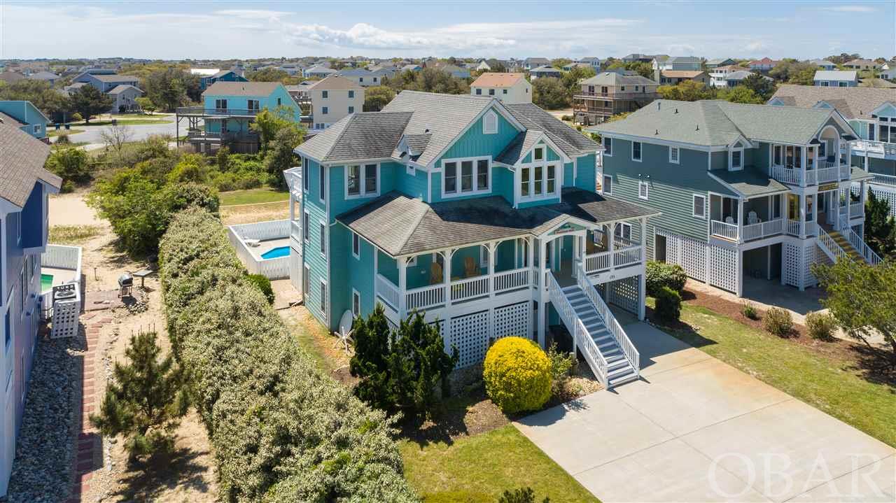 Exceptional opportunity to own a rare 8 bedroom home in one of Duck's premiere communities!  Located just 6 lots back from the community pool and recreation center and 7 lots away from the private beach access.  Proven, strong rental history.  Decorated with a lovely coastal style that compliments the architecture.  7 of the bedrooms have their own private bathrooms.  The floor plan lends itself to entertaining a large group and is sure to be a crowd pleaser.  Ground level entry with tile floors and family room opens to the pool area.  The pool area has a tiki bar and hot tub with baby pool for the kids.  The pool is an over-sized 16x32.  The ground level offers 3 bedrooms and 3 full bathrooms.  On the mid level there are 4 well appointed en suites.  The top level host a large, open great room, sitting area, and the largest of the en suites.  The top level sun decks overlook the pool area.  The kitchen is equipped to handle a large group with 2 dishwashers and beautiful granite counter tops.  All of the bedrooms on the south side of the home have doors that open onto the two levels of decks.  The beautiful landscaping was just updated.  Volleyball court in the back yard for the sports enthusiast.  Duck Landing is right in the heart of Duck and is an easy walk to the shops and restaurants and everything downtown Duck has to offer.