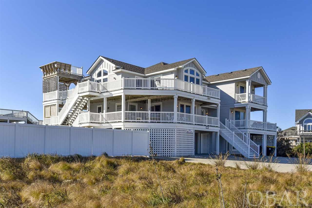 Just Beautiful Blue ... Ocean Views!  This exceptional Corner Semi-Oceanfront Beach Home that fronts on Atlantic Avenue toward the Atlantic Ocean is designed with 200’ of Frontage to capture more Ocean Views.  A Wonderful Great Room w Gas Fireplace, Dining & Kitchen Areas that provide Gathering Arenas for all to enjoy Ocean Views from every angle!  Your Kitchen is “Command Central”  with hooded Viking Gas Stove, Breakfast Bar, Quartz  Counter Tops, Two Dishwashers, Stainless Steel Appliances. The Rec Room w Billiards also has Kitchenette w Full Size Fridge & Ice Maker, all convenient to the Poolside Fun of the Private Pool & Hot Tub ...  and only seconds to the Beach Access, all of which make for an amazing Beach Vacation !  A  Large Private Swimming Pool is heated by heat pump (not expensive propane) which can be heated for renters for a weekly fee. And the well positioned Pool Area has ample Southern Exposure for Sunshine all throughout the Day, that makes for more splashin’ action. Then an adjacent horseshoe pit awaits for settling old scores. With Nine ( 9 ) spacious Bedrooms & Seven ( 7 ) Full Baths plus Two ( 2 ) Half Baths, you will have more room for Friends and Family.  Several Master Bedrooms have Bathrooms w Custom Tiled Showers & Jet Tubs.  All bedrooms are well appointed. Plus a separate Den on the Mid Level for Reading, Computer Office Setting, or Movies.  Perched on a Dune with a quiet Corner Setting, this Beach Home is only 200 feet from the beach walkway and less than 1 mile from the Corolla Lighthouse, The Whalehead Club, and lots of restaurants and shopping.  This huge Corner Site with 21,000 Sq Ft and  200’ of Ocean View Street Frontage is 1 of only 6  Lots in Corolla (other Communities have 100 ’ maximum ).  Being located in the sought after Beach Community of Ocean Hill, with Large 20,000 Sq Ft Lots, gives this Semi-Oceanfront the feel of an Oceanfront without the same costs and maintenance.  "Salty Dogs" is special with Lots of Decking, PLUS a Sky Deck for glamorous Ocean Views, sky Views of the & Moon & Stars.....plus direct views of Corolla  Lighthouse !   Parking Spaces for 9 ; Pool Size 15 X 35 ;  Quality Construction & Custom Built by Shoreline Builders.  Only 200’ to the Beach Access. New Air Conditioning & Heating System 2020.