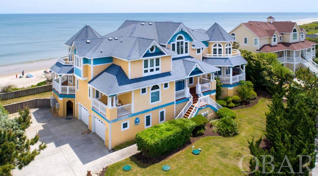 Panoramic OCEAN VIEWS!! This home has it all! Spacious (~7,500 sq ft) 8 bedroom luxury oceanfront home in the alluring gated community of Spindrift in Corolla. This home offers luxury and privacy with its classic Victorian architecture and modern conveniences and upgrades. This home sits on a beautifully landscaped oceanfront lot boasting gorgeous views of the Atlantic, expansive gathering areas, and spacious bedroom suites. On the top floor you'll find lofty ceilings, classic columns, giant custom windows overlooking the Atlantic Ocean, and open living space in the main living area. The living room and ocean view sitting area open to the dining room, an open ship's watch, breakfast nook, and gourmet kitchen. Any chef will be impressed with the large kitchen complete with professional cookware, abundant countertop and storage space, two glass cooktops, two ovens, two new dishwashers, four sinks, and an island with seating for three. You can choose to dine at the large dining room table, in the comfortable breakfast nook, or even outside on the fully furnished sun deck with amazing views. Also on the top level is the media room, laundry, and master suite with a spiraling four-poster king bed, deck access, sitting room and bathroom with double vanities, antique mirrors and chandelier, whirlpool tub and five foot marble shower with dual shower heads.  The mid-level begins as you walk in the elegant grand foyer with the circular staircase and granite floors.The foyer opens to an oceanside library and den area, great for relaxing. On this floor is five bedrooms and another laundry room, including two oceanfront king bedrooms with shared bath and deck access, two other king master bedrooms with deck access, and a master bedroom with two queen beds.  The ground level hosts great entertaining space with a game room with pool table, foosball table, air hockey table and kitchenette, as well as another media room with plenty of seating. Also on the first level is a two car garage and two master suites, one with two queen beds, and one with a queen and a daybed.  The rec room directly opens up into all that the outdoor space has to offer, including the large 16' x 32' private pool, hot tub, over 120' of oceanfront, and direct access to the beach walkway. New updates in April 2018 include new carpeting on second and third levels and new sand fencing on oceanfront. In 2019 two new dishwashers, new double oven, and new stackable washer/dryer.