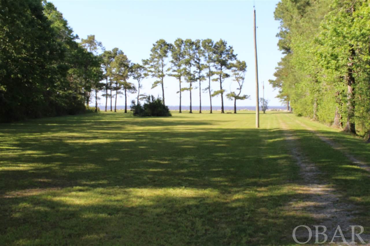 1.85+/- ACRES ON ALBEMARLE SOUND This unique waterfront property is accessed by a private lane that opens up into a beautiful view of the Albemarle Sound. There is existing septic system, public water, and electrical at the shore. Approximately 200' of water frontage. Rip rap shoreline stabilization structure. No HOA. Excellent site for a new waterfront home. Gorgeous sunsets! Within minutes of the N. C. OBX!