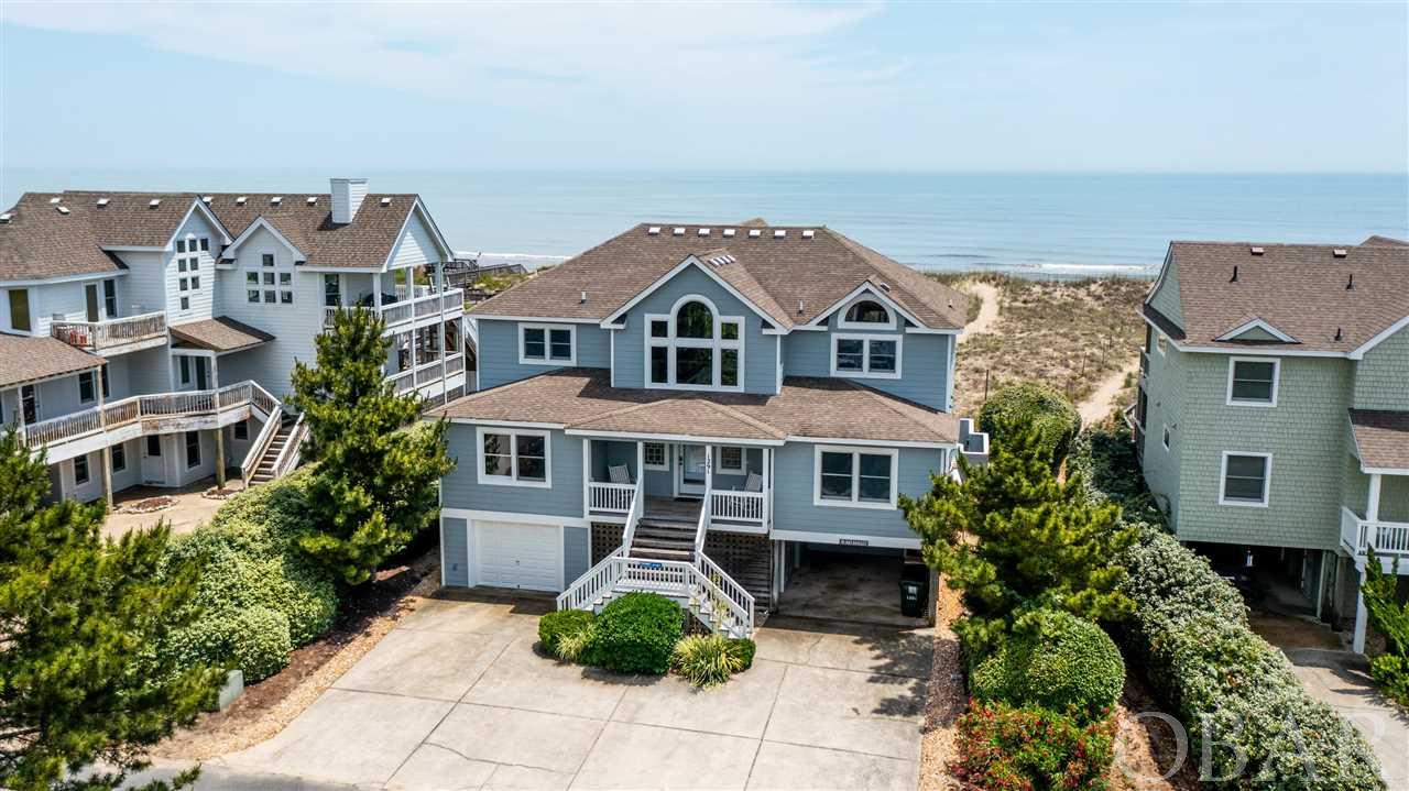 Quality constructed & impeccably well maintained oceanfront home in the sought after Villages at Ocean Hill community of Corolla. Boasting panoramic views of the ocean, along with an extensive list of interior updates from flooring to kitchen,  it's no wonder this home has been kept & loved by the original owners since built! On the top floor, a spacious great room with gas fire place & entertainment center, tiled kitchen with large island, dining area, granite countertops & ocean views, master bedroom with whirlpool tub & private deck. The mid level offers 4 master bedrooms, den/library/TV room & 1/2 bath. On the lower level, 2 bedrooms, a full bath, laundry room, garage & game room with kitchenette that leads out to your full size private pool & hot tub. Community amenities include ocean & lakefront pools, tennis courts, fitness center, playground, basketball court, volleyball/shuffleboard court, 10 acre lake & pedestrian walkways throughout. Enjoy the convenience of shops, restaurants & sites in the Historic Corolla Village. Consistently strong rentals year after year!