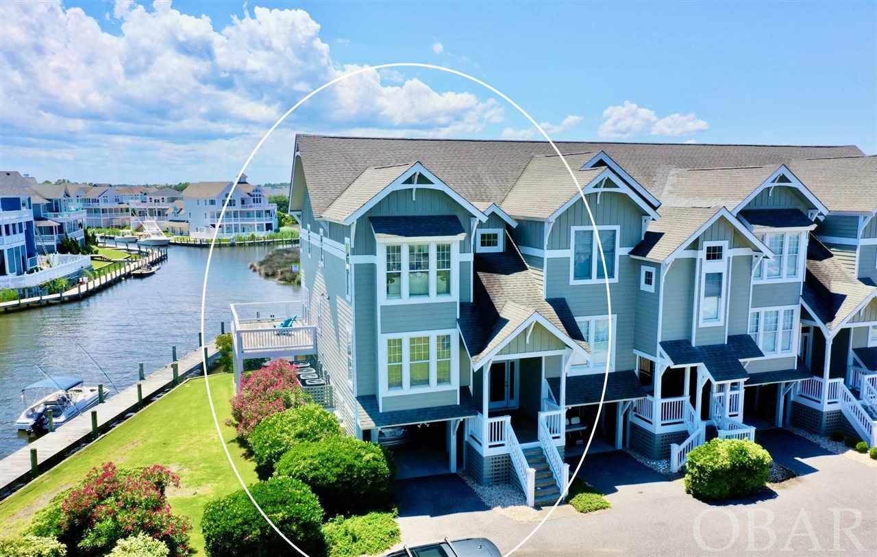 A Boater's & Fisherman's WATERFRONT LIFESTYLE & PARADISE! This WELL-MAINTAINED, NEVER RENTED townhome is a sensational rare find with unobstructed WATER VIEWS from every room in the home! An END UNIT featuring water and dock on 2 sides of the home with WIDER EXTENDED DECKS compared to other units, an absolute delight when lounging and entertaining! Bring your boat for your 30' BOAT SLIP located right beside the home & invite your friends & family to stay with 3 SPACIOUS ENSUITE BEDROOMS with WALK-IN CLOSETS lending plenty of PRIVACY for all guests. The Mid-level boasts an OPEN-CONCEPT Living area complete with Living room with 10' HIGH CEILINGS, GAS FIREPLACE, Kitchen w/Pantry and lovely WATERFRONT DINING Room. Built-in SPEAKERS throughout Top level includes two spacious master suites with vaulted CATHEDRAL CEILINGS , and a Laundry Room. The largest bedroom suite features shower, separate JETTED SOAKING TUB, plus private balcony.  That's not all, there's extended Outdoor living space on the mid-floor decks surrounded by water and a fantastic ground level patio-style deck where you can lounge out of the sun in your hammock while watching all of the boaters come and go from their fun days on the water plus Crab and Fish right from the dock! The Owner's Pool is just across the canal and generally stays pretty quiet compared to the main community pool for renters making it easy to keep an eye on friends and family! A DRY ENTRY 2-Car Carport lends access to plenty of storage and workshop spaces with additional fridge and freezer to keep cold beverages and snacks close by. The end unit also offers additional parking in front of the retaining wall which comes in handy! Pirates Cove offers LOADS of AMENITIES including two swimming pools, one for owners only and the other for guests/vacation rentals with snack bar and clubhouse. Security, fitness center, tennis courts, volley ball court, lighted docks to walk, fish or crab from. Adjacent to Pirates Cove is Pirates Cove Yacht Club. A full service marina, ships store, tiki bar and restaurant. The exterior was freshly painted 2 years ago, HVAC 2015. All Smart TVs with built-in Roku. NEVER flooded and this unit is more sheltered from severe weather than soundside properties. AV Closet on landing needs a tuner and amplifier and will control speakers (also control pads on walls in rooms). Perfect for a family or investment, don't let this one slip by!