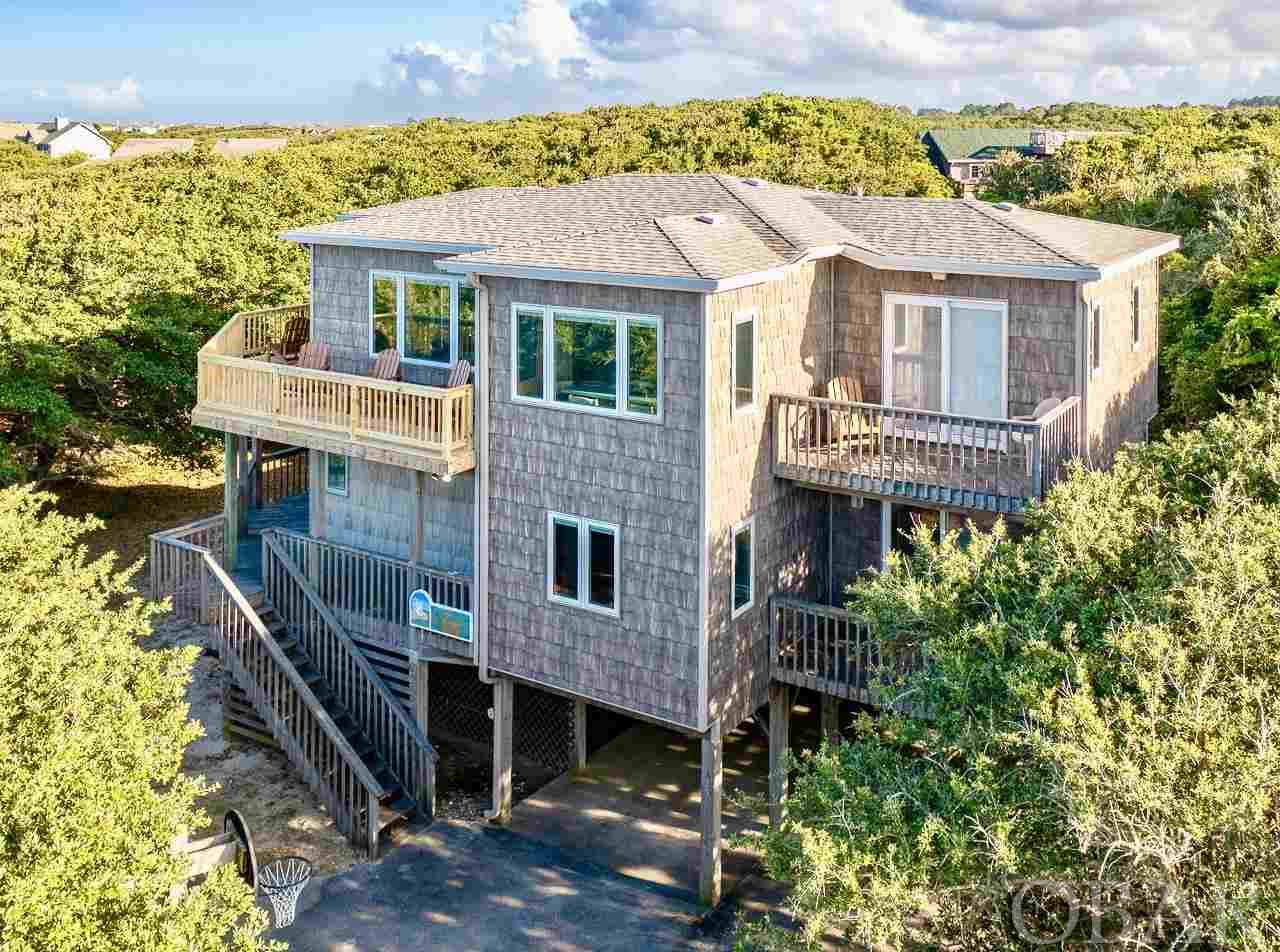 Relax to the Soothing Sounds of the Ocean from one of the multiple large wrap-around decks at this well maintained oceanside home in Southern Shores. Separated by only 5 homes from the Beach,  "Conch Out" is located on one of the nicest streets in the Seacrest Village Subdivision. Along with NO Streets to Cross and being located on a quiet private cul-de-sac with its own beach access, Thirteenth Avenue has a traffic light making access much easier during the peak season. Centrally Located with quiet uncrowded beaches, this home is only about 1 mile from Downtown Duck and it's many Shops, Restaurants & Bars.  This fully furnished multi-Level home has an open floor plan with a "pickled trim" tongue and groove wood cathedral ceiling in the living room as well as a Screened-in porch, and Brand New Upper Deck in 2021. Kitchen features newer Stainless Steel GE Appliances with bar seating.  The Game room has it's own bathroom and is currently being used as a sixth bedroom. Along with the convenient dry entry and double lane carport for under house parking, there is plenty of extra parking space for multiple vehicles.  Located in an X Flood Zone, No Flood Insurance is required. With plenty of mature landscaping, this home offers Lots of Privacy, an Outside Shower, Storage Room & Basketball Goal.  One of the Zoned HVAC units and Air Handlers was replaced in 2020. Roof was replaced in 2012 with 130 MPH - 30 year shingles. New Pella Triple Pane Designer Windows with blinds installed in 2013 as was the Cedar Shake Vinyl Siding. A Rental Projection of almost $80,000 per year will make this an outstanding Rental Income Investment. For a very reasonable membership fee of less than $100 per year, the Southern Shores Civic Association offers three Sound side Marinas with boat launch, picnic and crabbing areas, Private Sound Beach, thirty-four Private Ocean Beach accesses, parks and much more.