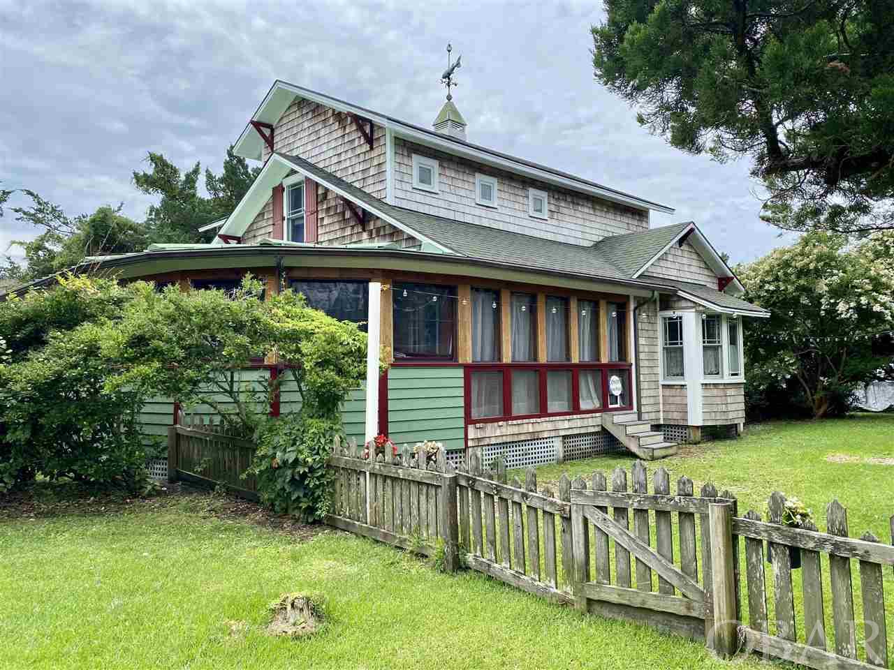 This exceptional property is located in the heart of the village, close walking distance to shops and restaurants.  The parcel contains 2 houses; the primary craftsman style home was originally built by Bertha and Van Henry O'Neal in '45 using materials from their Portsmouth island home as well as other defunct historic structures on the island adding to it's rich history.  A complete remodel was done by local contractors including descendants of original owners in 2004 resulting in a perfect balance of historic beauty and modern comfort. The downstairs consists of mud room/work space, kitchen, dining, living, bonus room, bedroom, full bath and large, enclosed and fully insulated wrap porch or sun room with removable panels allowing for conversion to screen porch.  Upstairs houses the master bed and bath in addition to a large open dressing room, work space with laundry facility.  Wooden beaded boards throughout entire house, vintage English stained glass accent panels built into doors, windows and walls, prairie glass mission style Pella windows and doors, , Koehler  soaking tub in master and farm sink in mudroom, on demand gas hot water, all new kitchen and appliances 2020, new HVAC 2020, custom vintage style faux "coal burning" gas fireplace insert in dining with art nouveau tiles, house fully wired for sound and cable, custom California Closet systems in master dressing room and walk in kitchen pantry and easy install, highly effective full storm shield shutter system for both houses.  Fenced in yard, large private outdoor shower and bike racks complete the package. "Charlotte's Daughter" is the 2nd cottage on the property which has been in a vacation rental  program since 2008 and has provided solid, consistent rental income.  The 2 story cottage was built by local contractor Larry Ihle for his mother in 1987 and is approx 790 square feet along with an 8 X 14' screened porch.  Open kitchen, living dining on first floor, master bed and bath on second floor. Lots of options here as there is potential for double income or the ability to generate income while maintaining exclusive use of one unit.  Both structures meticulously maintained and embellished with beautiful customized landscaping make this property highly desirable on so many levels.