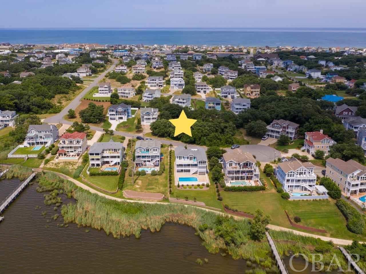 Ready to build your dream home with views galore?  Watch stunning sunsets over the sound from this beautiful semi-soundfront homesite, located in one of the most prestigious and sought after neighborhoods on the Outer Banks. Situated on a quiet cul-de-sac and just across the street from the community pier, kayak launch, and multi-use path, this property offers all you need to get settled into the coastal lifestyle.  First Flight Ridge is a private, gated community centrally located in the heart of Kitty Hawk within a quick walk or bike ride to numerous shops, restaurants and the beautiful Kitty Hawk beaches. The community backs to Kitty Hawk Bay and the Kitty Hawk multipurpose path perfect for walking, biking, running, you name it! The soundside community pier is a perfect spot where you will often find neighbors gathering to watch the sunset. The pier also has a launch platform ideal for dropping in kayaks and paddle boards. This location is just waiting for your dream home!