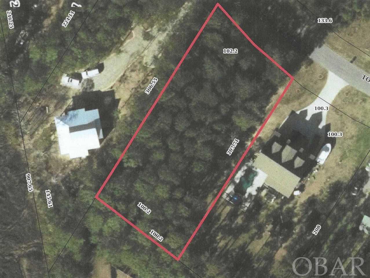 This spacious, secluded lot is conveniently close to the main thoroughfare through the Outer Banks.  Almost a half acre of wooded vegetation and 100 feet of street frontage will ensure privacy, and a significant portion of the lot lies in X flood zone!  Water tap has already been purchased and is included in the price!