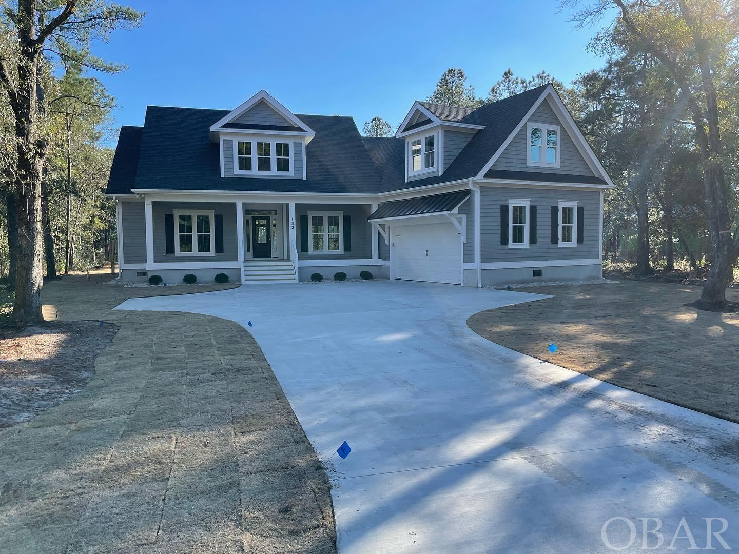 Dreamy NEW CONSTRUCTION on the North End of Manteo by BARKER & BARKER CUSTOM HOMES. The Croatan Woods neighborhood presents an opportunity to live on Roanoke Island's "North End," highly sought after for its tranquility, charm and rich history. The wooded subdivision is bordered by two wildlife preserves and offers a community nature trail leading to a soundside gazebo, sandy beach access, and a brand new pier. Take the dogs for a stroll to the sound, collect some driftwood, and head back to the house to enjoy the modern comforts of this design conscious home. Enter through the spacious two car garage, hang your bags at the custom drop zone and retreat to your groundfloor Master Suite. The luxe ensuite Bath showcases a custom tile shower, dual vanities, and upgraded tile floors, leading to a walk-in closet with built-in shelving. Two additional bedrooms on the main floor are accompanied by a convenient Jack and Jill Bath with two private vanities and tile floors. A sprawling room on the second level above the garage features a full bath and closet and can be enjoyed as a permitted fourth bedroom OR bonus room/office. The ultra modern kitchen boasts solid wood cabinetry, quartz countertops, tile backsplash, and GE stainless steel appliances. Between a large kitchen island, a breakfast nook, and a formal dining room, there are ample dining options for family and friends while the open concept layout and powder room make the space perfect for entertaining. The great room affords both comfort and elegance, outfitted with 9ft coffered ceilings, crown molding, wood beam accents, a gas fireplace, and hardwood floors throughout. Move the party outdoors to the screened in porch or patio to enjoy a famous Outer Banks sunset or the sounds of nature. The stylish details of the home's exterior leave nothing to be desired when it comes to curb appeal. You'll find fresh sod, a fully landscaped yard with an irrigation system, a covered porch, board and batten shutters, and durable LP Smart Siding. There is also room for a pool. While the home comprises top of the line finishes throughout, an early contract affords the buyer some creative control with an opportunity to upgrade and customize. Construction is in progress and estimated to be completed in December 2021. Don't delay folks, THIS IS THE ONE!
