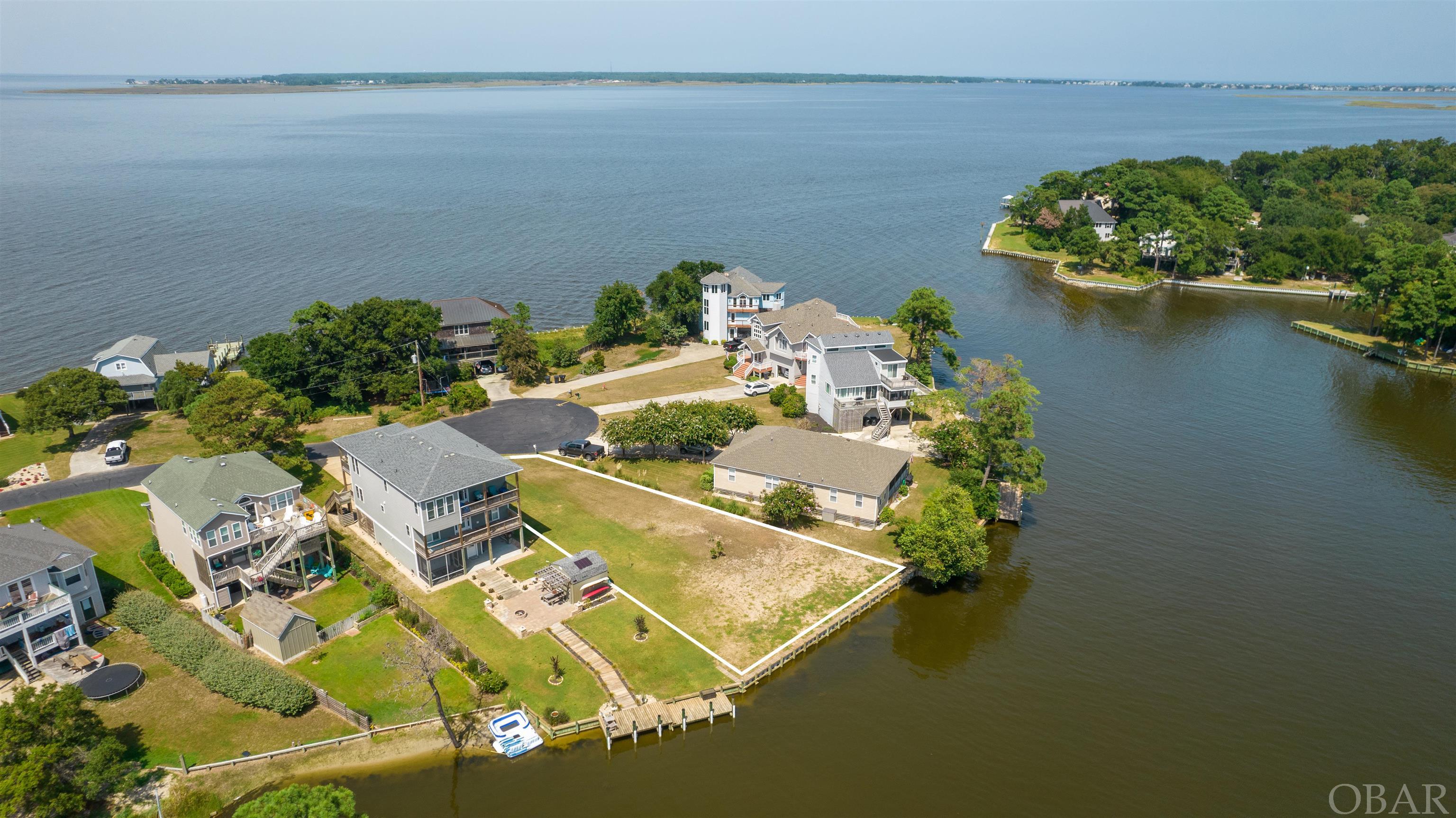 What a WONDERFUL opportunity to own a lot on a lake (reads more like large, wide, Canal that opens into Eagleton Point) in the Albemarle Sound off of Colington Island!  Over 80' of New Vinyl Bulkhead installed in 2021 borders flat and grassy Lot 24. Paddle a kayak in the quiet calm behind your lot or explore the sound to fish, swim, boat, sail, stand-up paddle board or create your own aquatic adventures!  Clipper Court is a short walk or bike ride to Colington Harbour Soundside Park which includes beach access, picnic area, playground, boardwalk and boat ramp.  Explore the possibilities of building your dream home to capture those amazing waterfront Sunsets! For approximately $100 joining fee and $200 per year, you may become a member of the Colington Harbour Yacht and Racquet Club (CHYRC.org) and enjoy the Clubhouse, pool and tennis courts.  Annual Association Fees are approximately $299 per year and include guarded gate, common areas, basketball court and maintenance of amenities. AE and X Flood Zones.