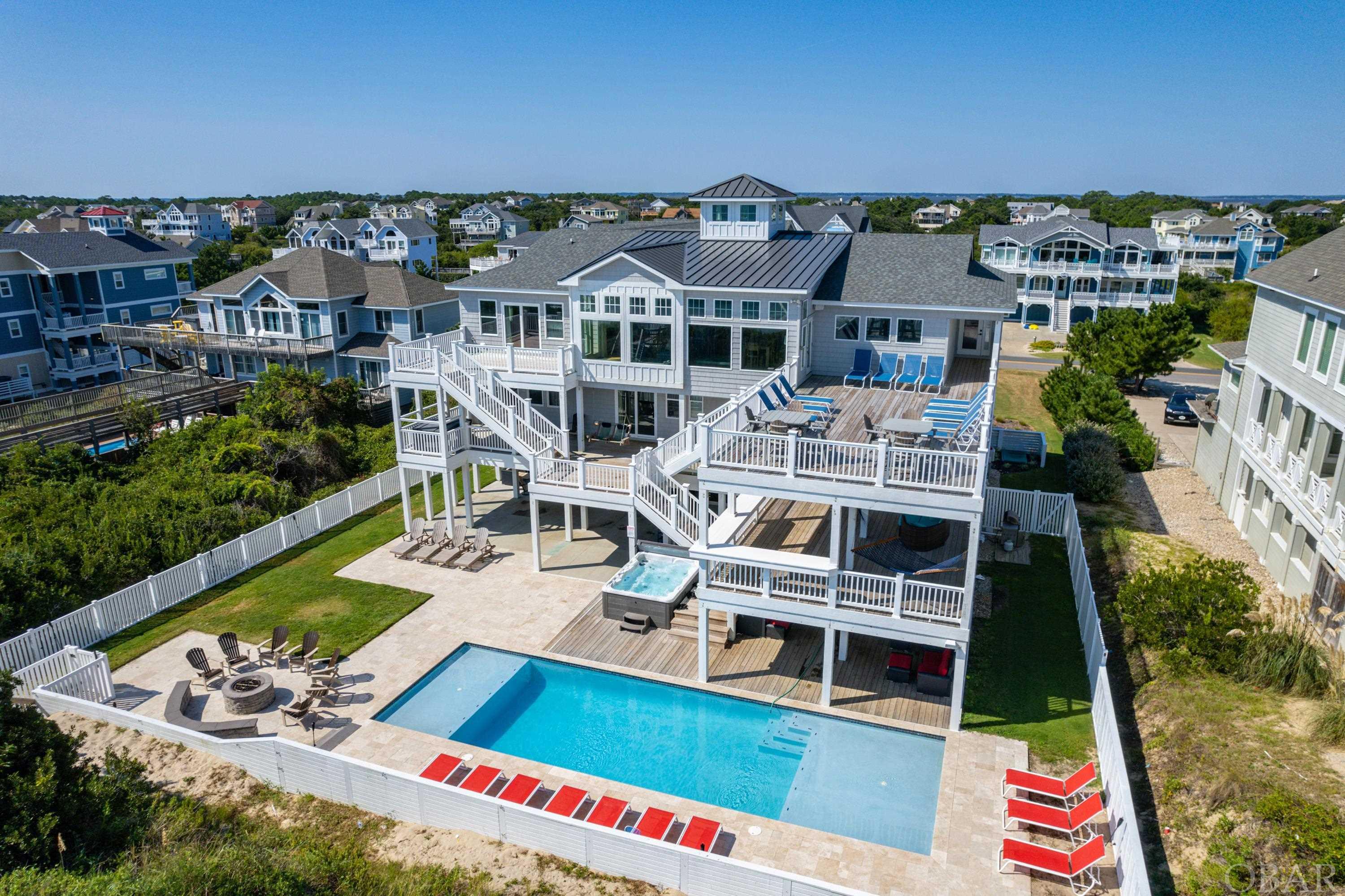 Fantastic Advertised Rate Income 2021: $437,412.75 and with Owner Weeks Added $484,258.  "Lighthouse Twelve"….Simply Wonderful ….... Being on the Ocean at Lighthouse Twelve, gives one and all Magnificent Oceanfront Beauty at it’s Best !  Glorious amounts of glass windows provide a multitude of Ocean Views, capturing dancing surf splashing before you.  ….even the Kitchen gets the splendor of more Ocean Views.  Lighthouse Twelve's Design is ideal for Weddings, Re-Unions, Conventions, and Loved Ones.  Luxury Furnishings abound, beckoning you to relax. This Location is precious, as being in the middle of the block creates a Private Beach feel just for your pleasure. Lighthouse Twelve’s fantastic multiple Decking Settings makes it so relaxing to just become part of the Ocean’s enriching ambience.  The inviting flow of this Oceanfront Beach Home embraces you with excitement, as Lighthouse Twelve is designed for FUN.  The Top Level Great Room  commands incredible Ocean Views with Four Large Glass Panel Windows !  The Living Area has Large Flat Screen, an easy lite Fireplace, Majestic Dining Table for 18  with grand Ocean Views. Huge Kitchen convenient to all the action and has excellent Ocean Views too .... and Counter Seating for Four more. Just off the Great Room is a Setting Area with Wet Bar, Ice Maker, and cabinetry of glassware to choose from, for your libation to be refreshing and immediate.  Enjoy an especially nice & separate private Recreation Room with Billiards, Kitchenette, Flat Screen, Full Size Fridge, & Ocean Views too.  As the Ocean Waves are splashing on shore of the wide Beautiful Beach of Corolla, you see and hear the Ocean from all angles with Oceanfront Decking in abundance ! Ideal for Outdoor Dining, ample Sun Decks, Gatherings in the Shade, refreshing Ocean Breezes, and enchanting Water Views.  Of the Twelve Bedrooms w Private Baths, Four are convenient to the Top Level living areas.  Seven Bedrooms are on the Mid Level, including one as a combo Bedroom & Mid Level Den. The advantage of the Mid Level Den Design is that one is greeted with an Ocean View as soon as you walk in the Front Entry Foyer.   Convenience of an Elevator makes Life Easy.  Tucked away also on the Mid Level, is the separate Theater Room, to enjoy movies or the big game ! Outdoors there are even more additional Decks and Lounge Chairs at the Top Level, Mid Level, Dune Top, Poolside, and around the outdoor Fire Pit, too.  At Poolside, Wet Bar with Two Full Size Fridges, Large Flat Screen TV and an abundance of Cushioned Sofas, which lets the party continuously flow from the Top Level to the Poolside Level.  ! One can stroll along the Beach for miles…all of which makes this shorefront Beach Home as “One to Cherish”.  The Top of the Dune Deck and Lounge Area, is perfect to enjoy refreshments and to be revitalized by the tropical ocean breeze.  Various outdoor seating and decking provides a multitude of perspectives to enjoy the ocean essence.  All separate, yet close, to easily re-engage in all the action. The Pool & Two Hot Tub offers more ways to enjoy the Best Setting on the Ocean.