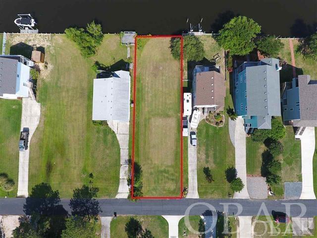 Don't miss this prime building site with 50' of water frontage on a deep water canal! Already bulkheaded and ready to be built upon! Just a few minutes by boat out to the sound. Located in the gated community of Colington Harbour, enjoy neighborhood amenities including an outdoor community pool, clubhouse, tennis courts, sound side park and beach. Previous owners have already brought in fill and lot is clear and ready for your Outer Banks dream home to be built on! New survey and perc test in docs.