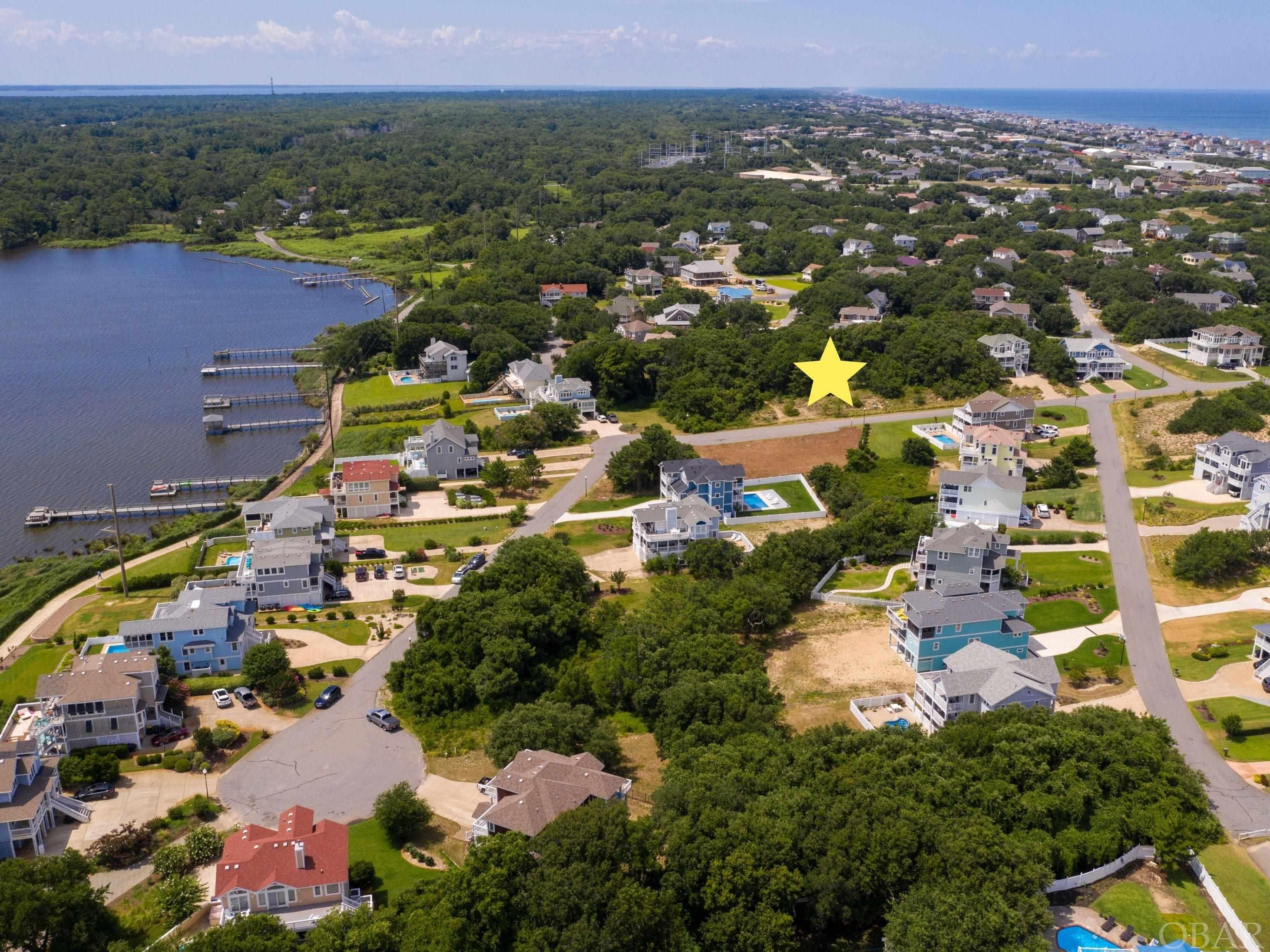Ready to build your dream home in one of the most prestigious and sought after neighborhoods on the Outer Banks?  Look no further than this fantastic soundside homesite in First Flight Ridge!  Situated steps from the community pier, kayak launch, and multi-use path, this property offers all you need to get settled into the coastal lifestyle.  A reverse floorplan home should afford stunning sunset views over the sound.  First Flight Ridge is a private, gated community centrally located in the heart of Kitty Hawk within a quick walk or bike ride to numerous shops, restaurants and the beautiful Kitty Hawk beaches. The community backs to Kitty Hawk Bay and the Kitty Hawk multipurpose path perfect for walking, biking, running, you name it!  The soundside community pier is a perfect spot where you will often find neighbors gathering to watch the sunset. The pier also has a launch platform ideal for dropping in kayaks and paddle boards. This location is just waiting for your dream home!