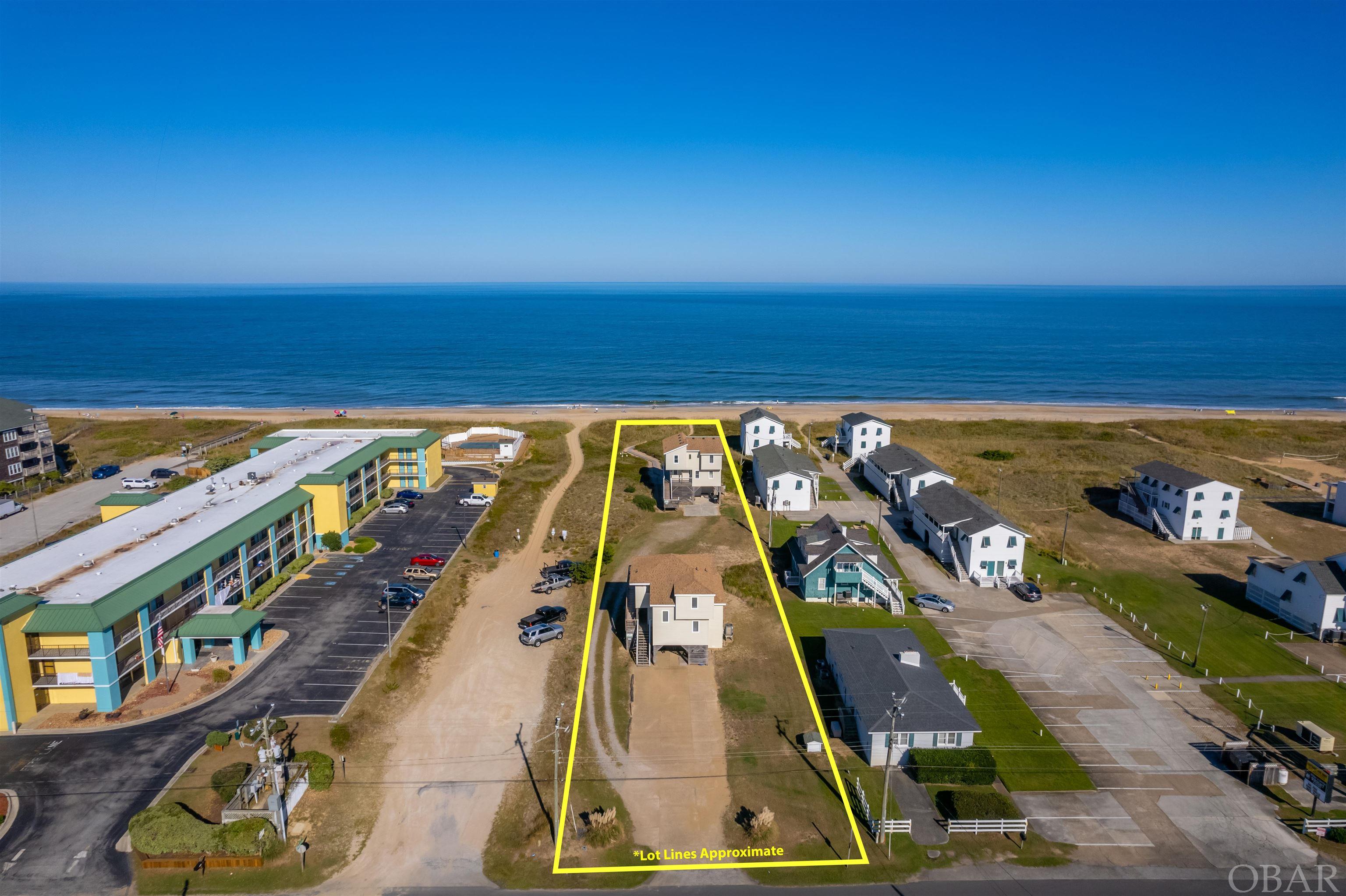 High elevation, 75 foot wide oceanfront lot with 2 existing homes.  Opportunity to start new and rebuild a large oceanfront income producing property or renovate/ update existing homes and room to add another home.  Endless potential.  The 2 homes are each 4 bedrooms and both have views of the ocean and the Wright Brother's Memorial.